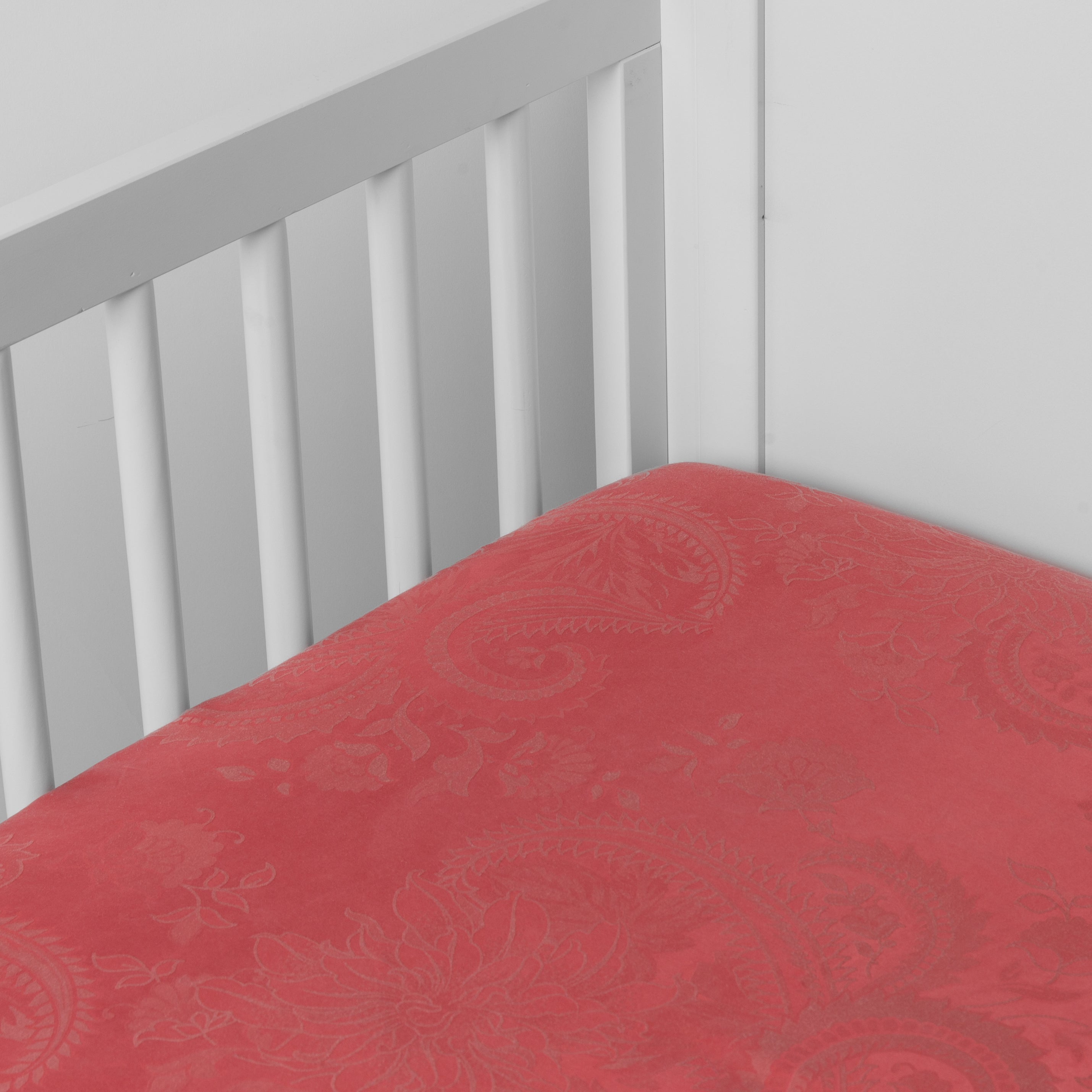 Poppy: a silk and tencel™ crib sheet shown slightly overhread and shot into the corner of a white crib.