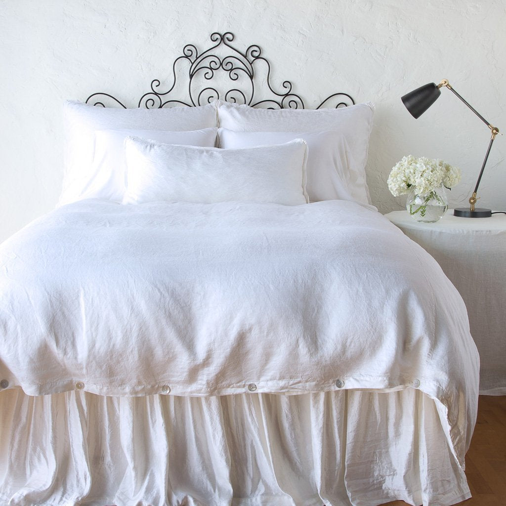 White: duvet cover with matching pillows and bed skirt - end of bed view.