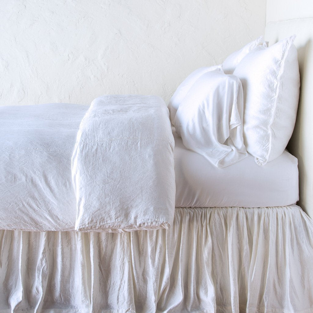 White: duvet cover with matching pillows and bed skirt - side view.