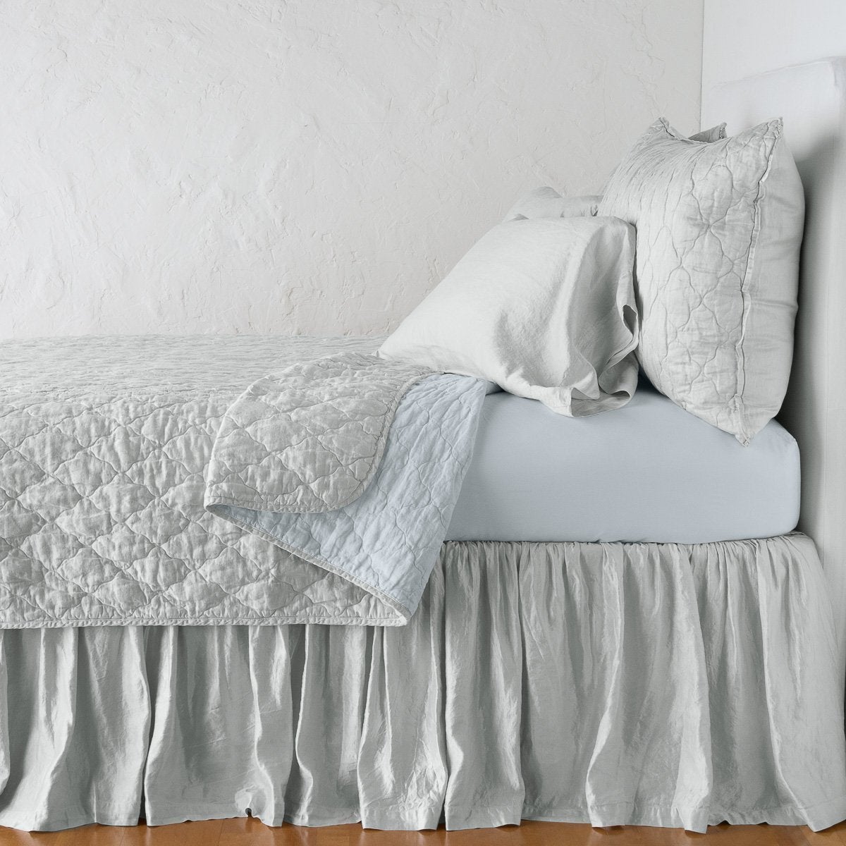 Cloud: sleeping pillows on a monochromatic charmeuse bed - side view.