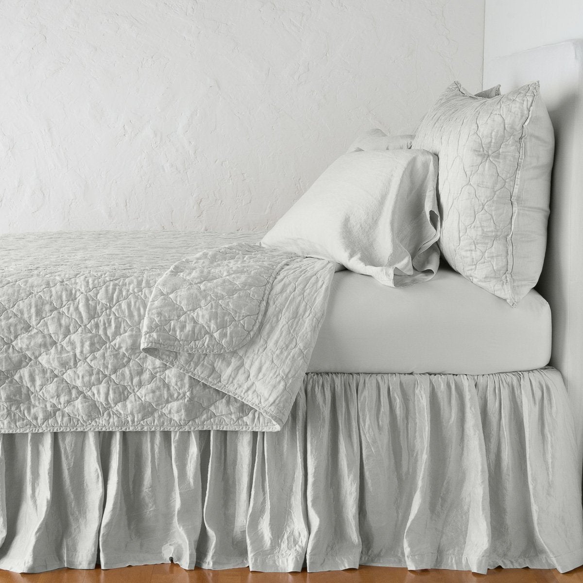 Sterling: sleeping pillows on a monochromatic charmeuse bed - side view.