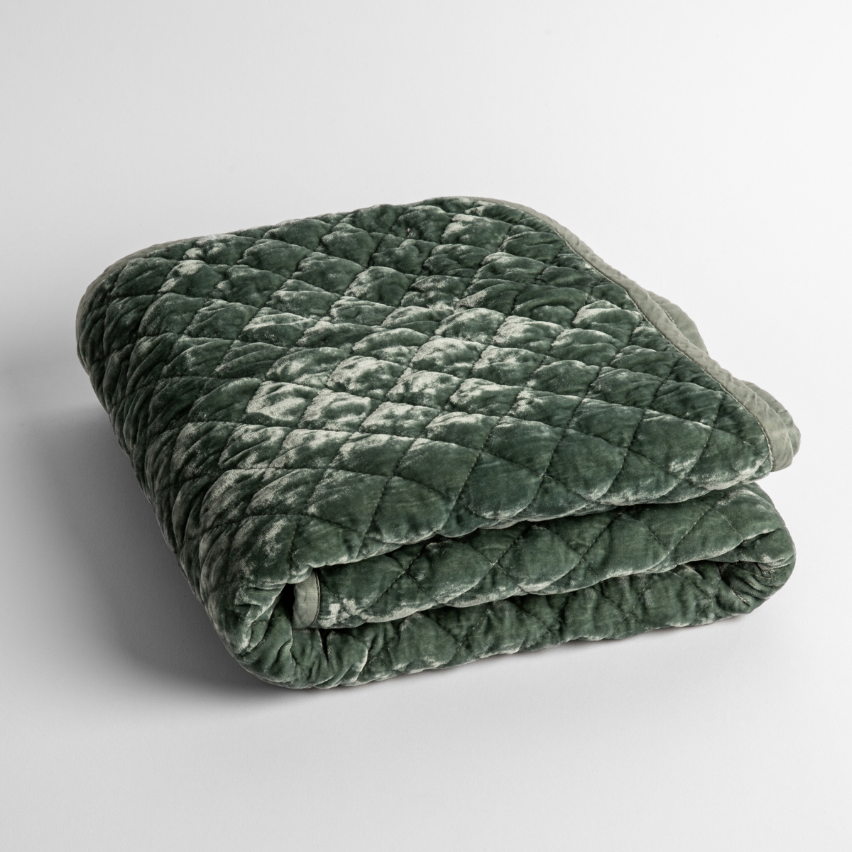 Eucalyptus: a folded quilted silk velvet baby blanket shown from overhead to showcase quilting pattern and texture.