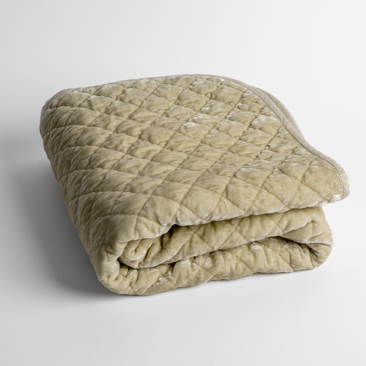 Parchment: a folded quilted silk velvet baby blanket shown from overhead to showcase quilting pattern and texture.