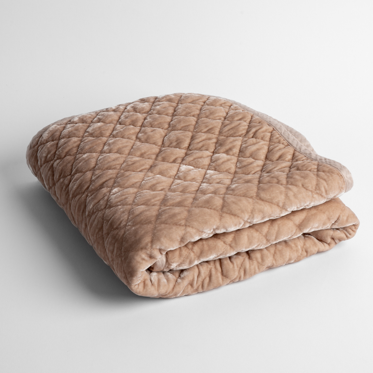 Pearl: a folded quilted silk velvet baby blanket shown from overhead to showcase quilting pattern and texture.