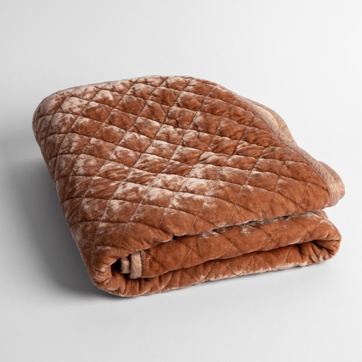 Rouge: a folded quilted silk velvet baby blanket shown from overhead to showcase quilting pattern and texture.