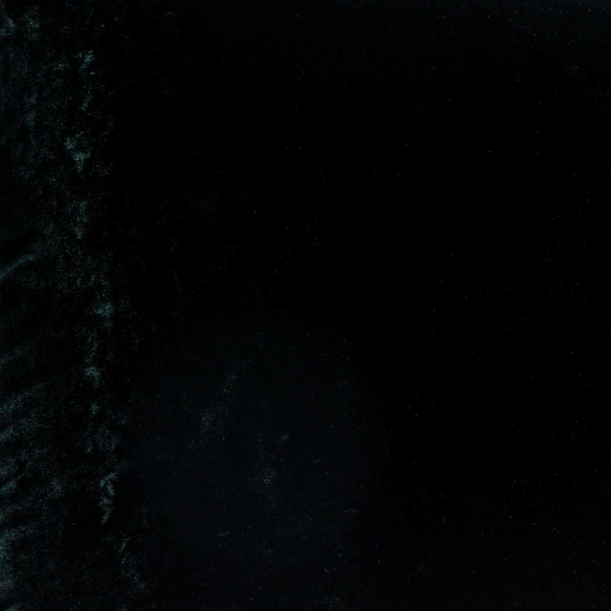 A close up of silk velvet fabric in Juniper, a deep green tone.