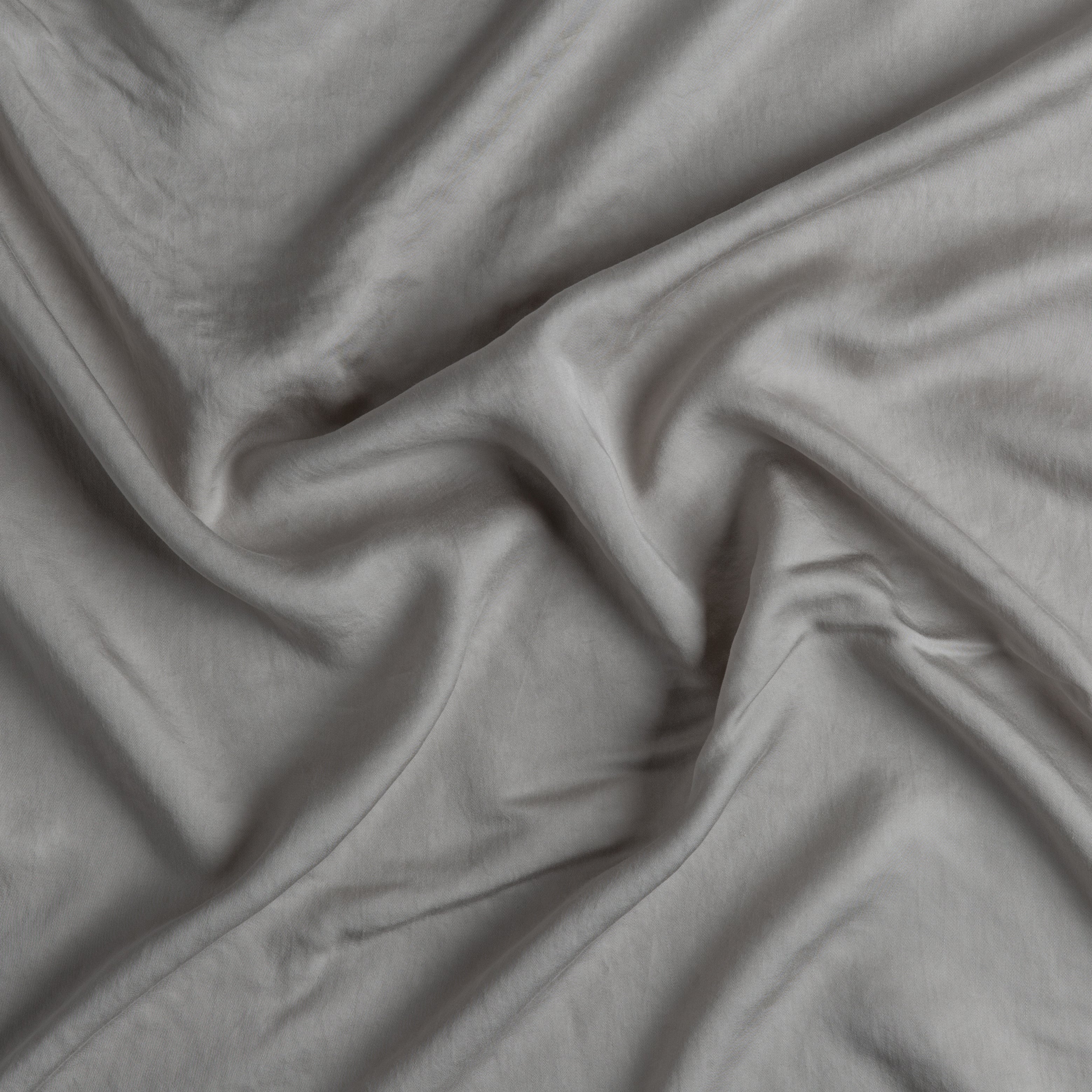 Fog: A close up of Tencel™ fabric in fog, a neutral-warm, soft mid-tone grey.