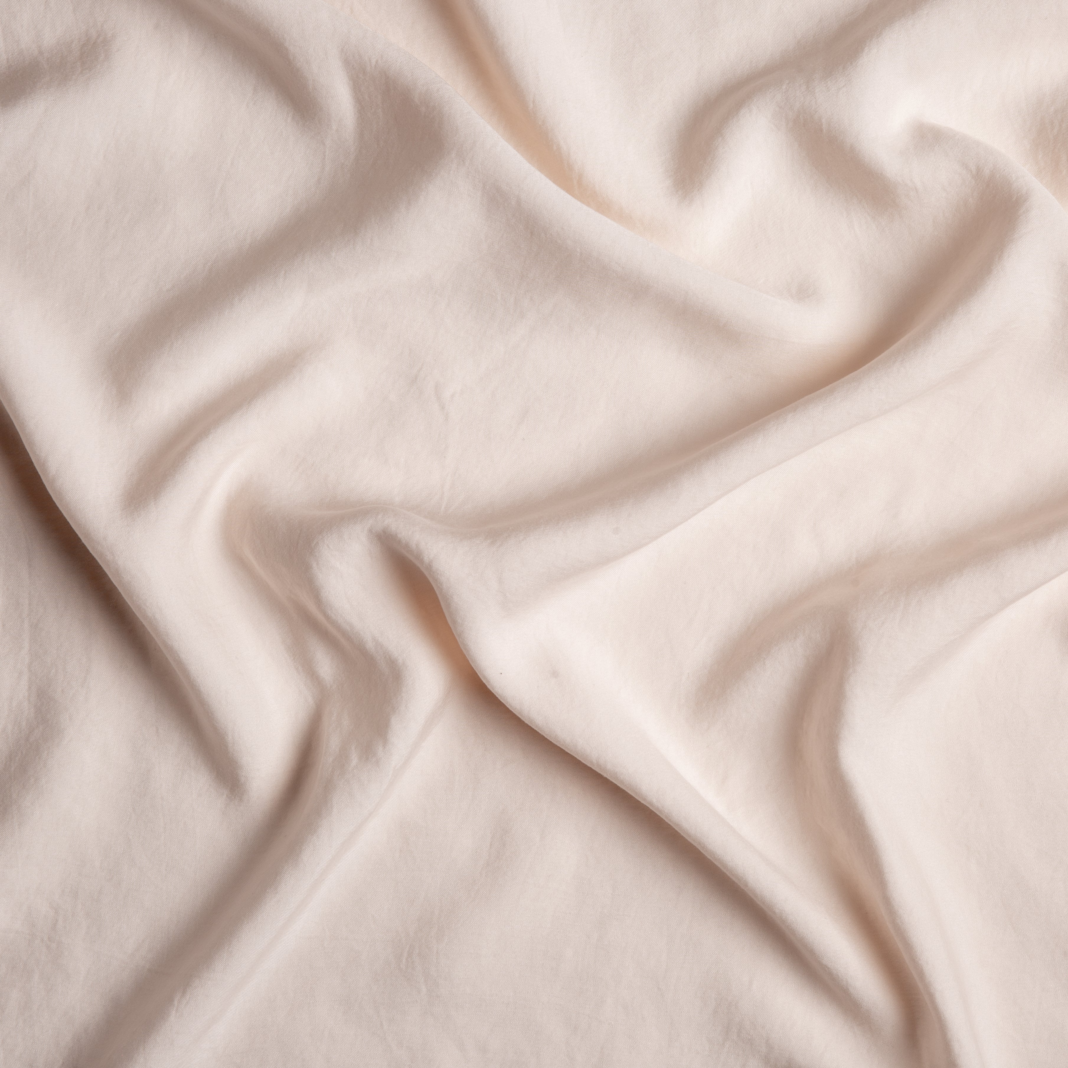 Pearl: A close up of Tencel™ fabric in pearl, a nude-like, soft rose pink tone.
