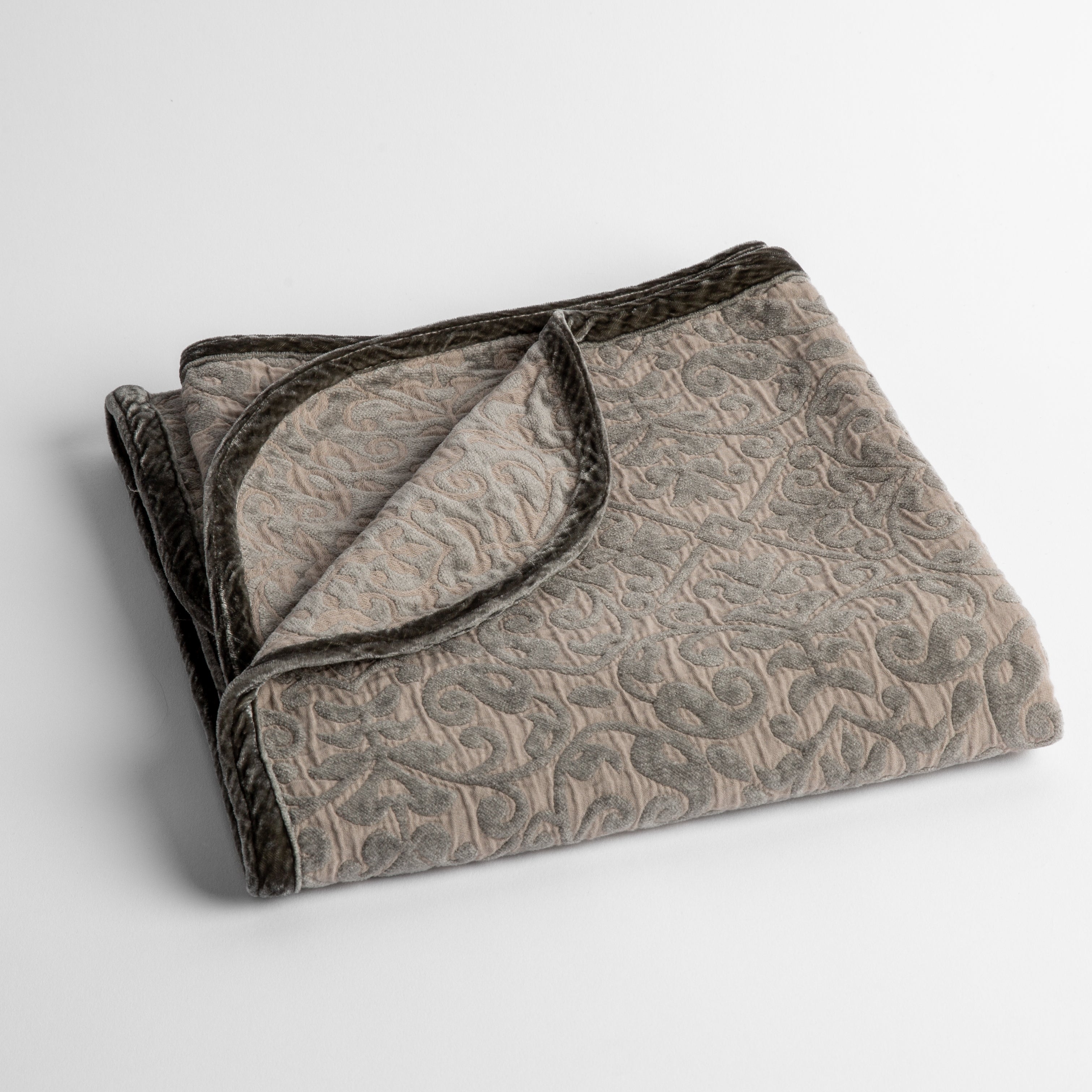 Fog: a folded cotton chenille baby blanket trimmed in silk velvet shot overhead at a slight angle against a white background.