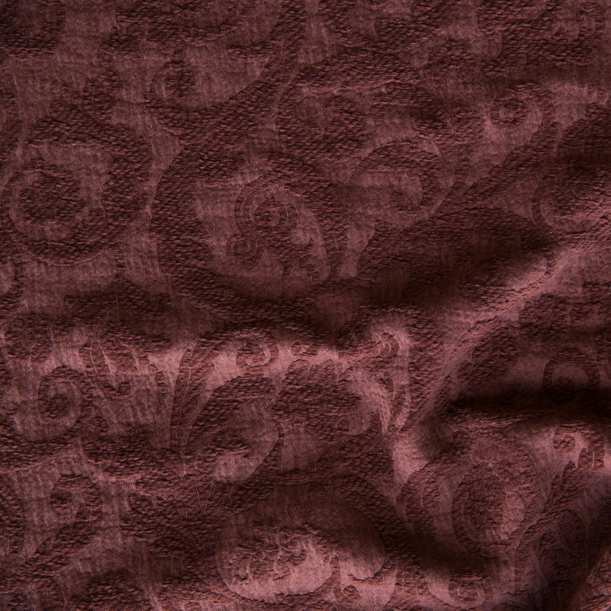 Mahogany: A close up of Adele fabric in mahogany, a deep, earthen, reddish brown. The fabric is rumpled to show the cotton damask texture.