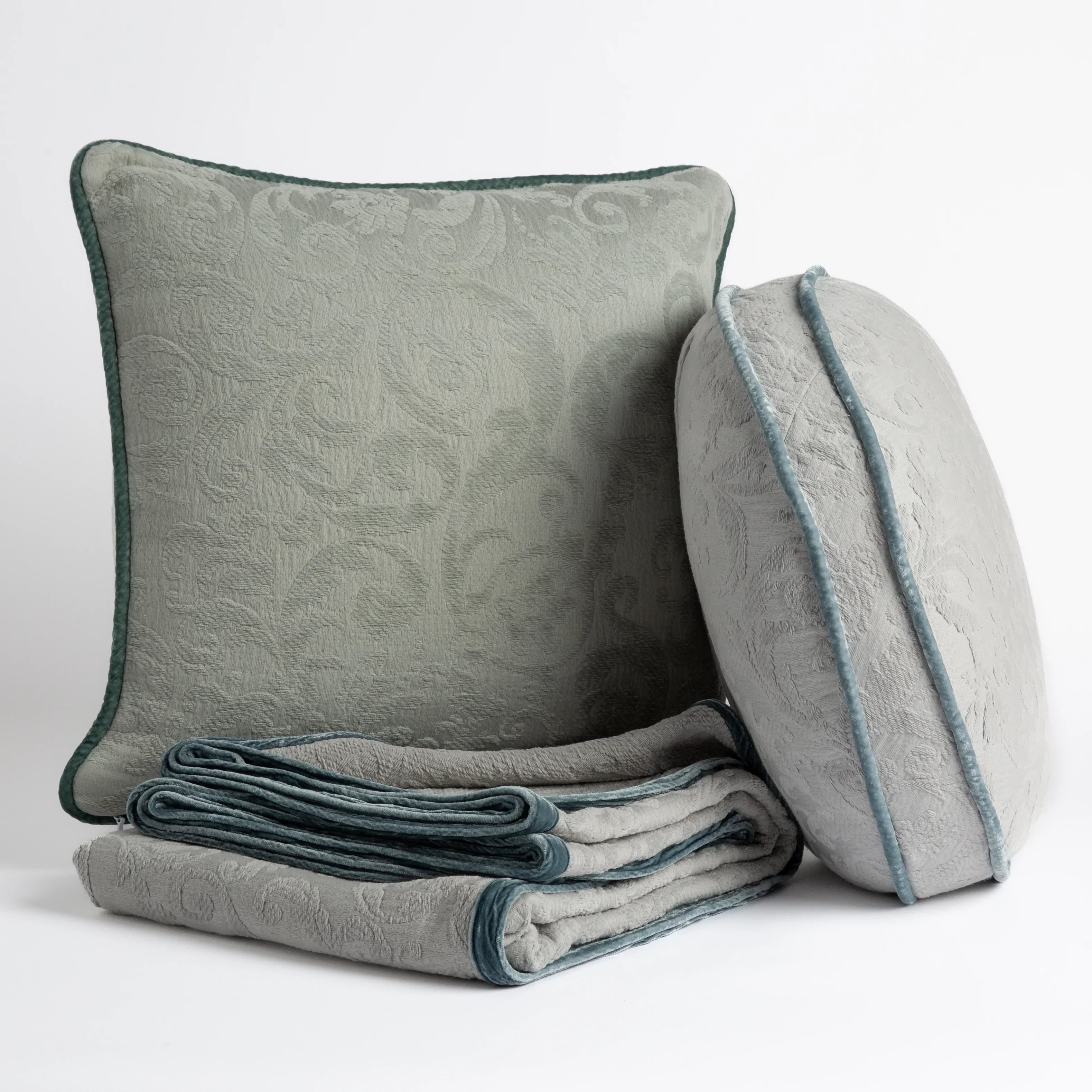 : Organic cotton damask throw pillows and throw blanket on a white background.