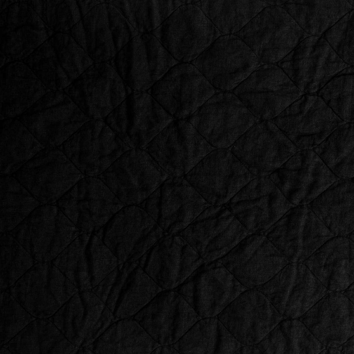 Corvino: A close up of quilted midweight linen fabric in Corvino, a black tone