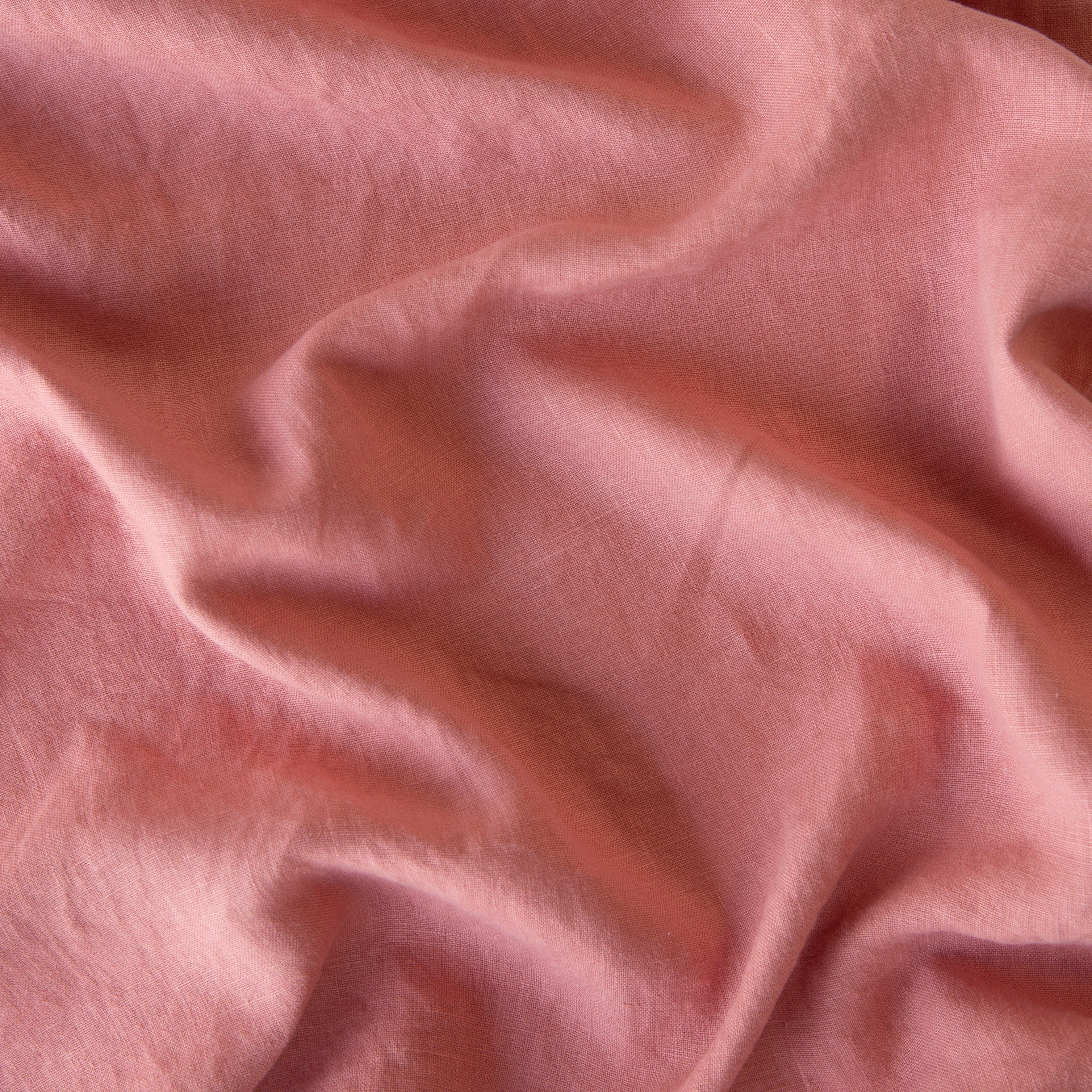 Poppy: A close up of midweight linen in poppy, a warm coral pink.
