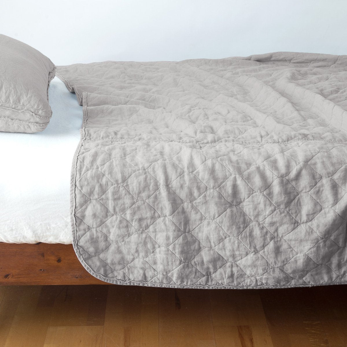 Fog: quilted midweight linen coverlet on a bed - side view.