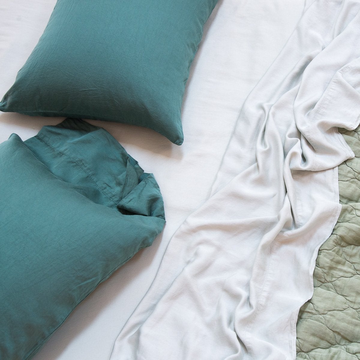 : Madera Luxe sheeting and pillow cases with a quilted Luna coverlet, in various shades of green - overhead view.