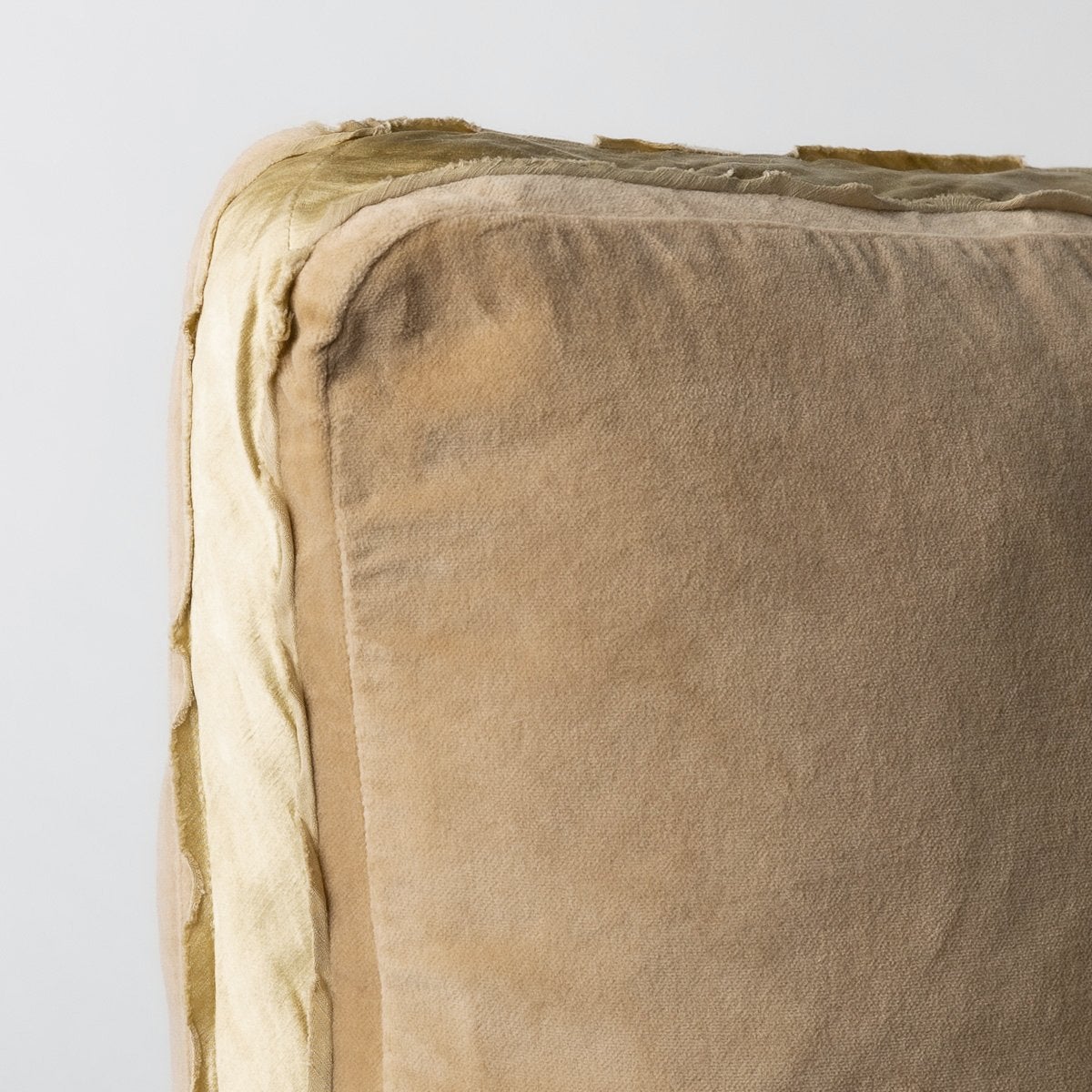 Honeycomb: Corner detail close-up of honeycomb Harlow 24 by 24 pillow, showcasing charmeuse gusset and raw edge trim.