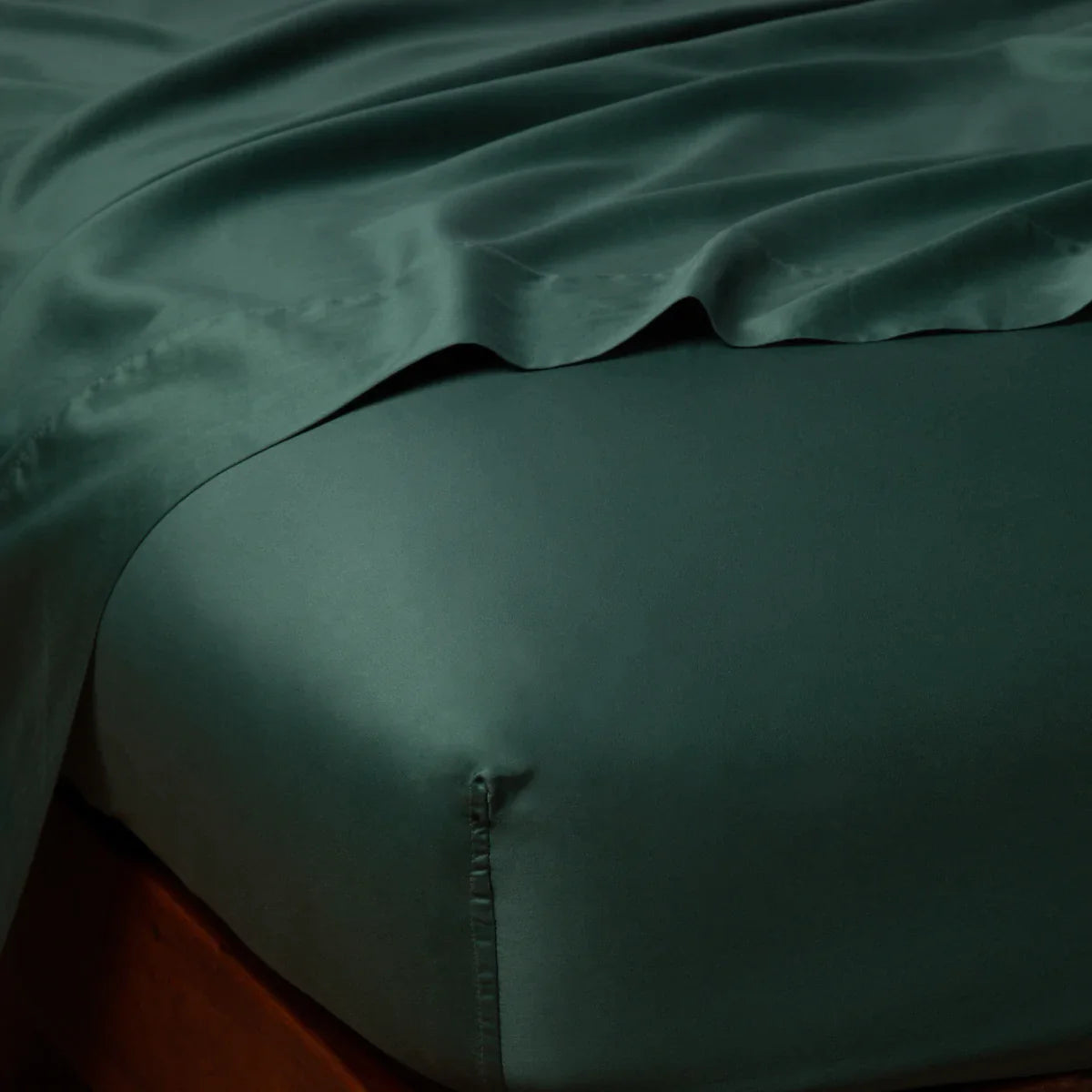 Jade: Cotton sateen fitted sheet shown from the top corner, highlighting the shine of the fabric.