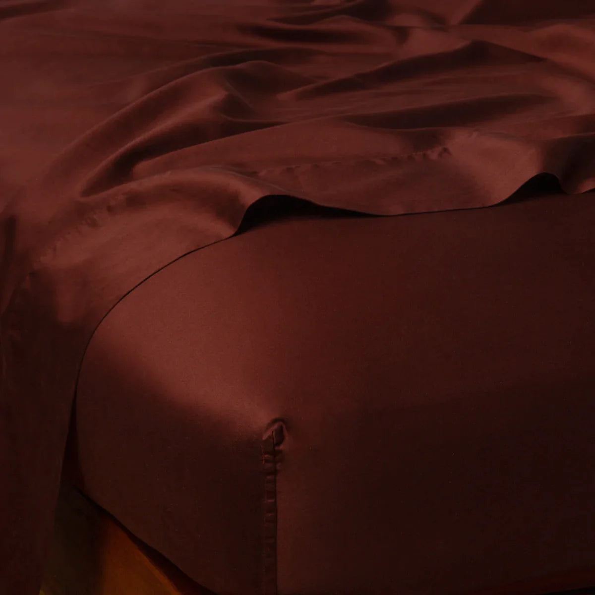 Mahogany: Cotton sateen fitted sheet shown from the top corner, highlighting the shine of the fabric.