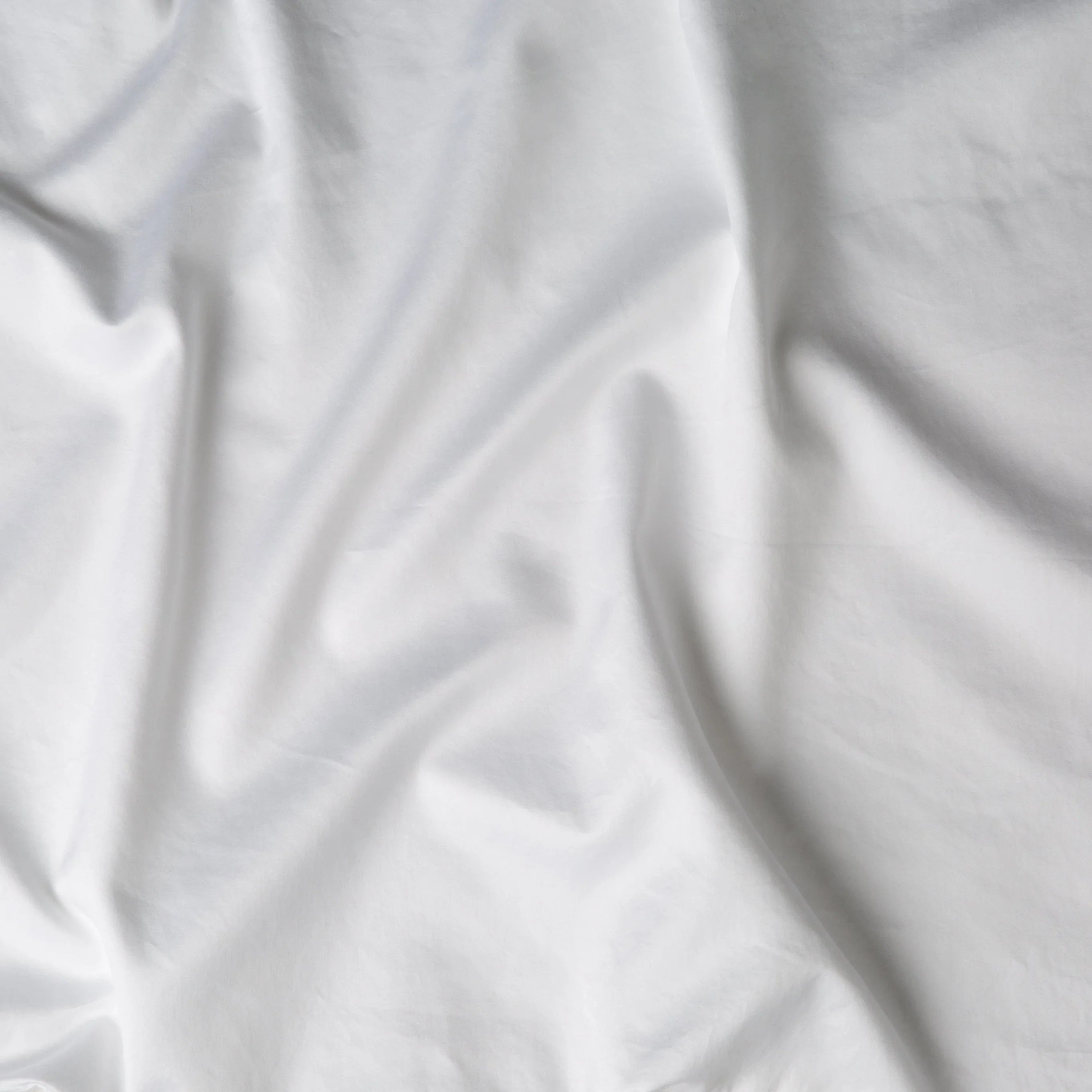 White: A close up of cotton sateen fabric in white.