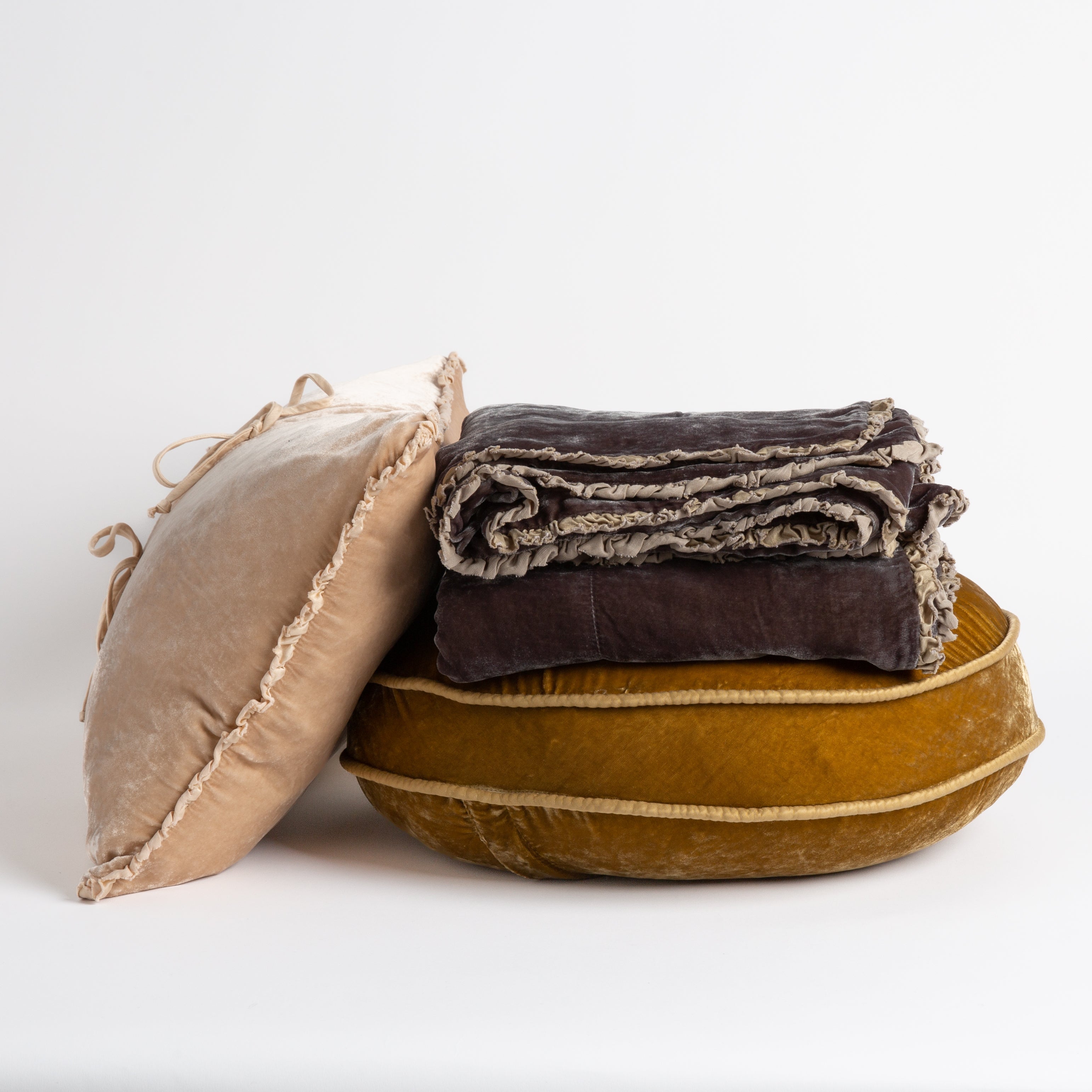 : silk velvet throw pillows and throw blanket on a white background, trim details are visible.