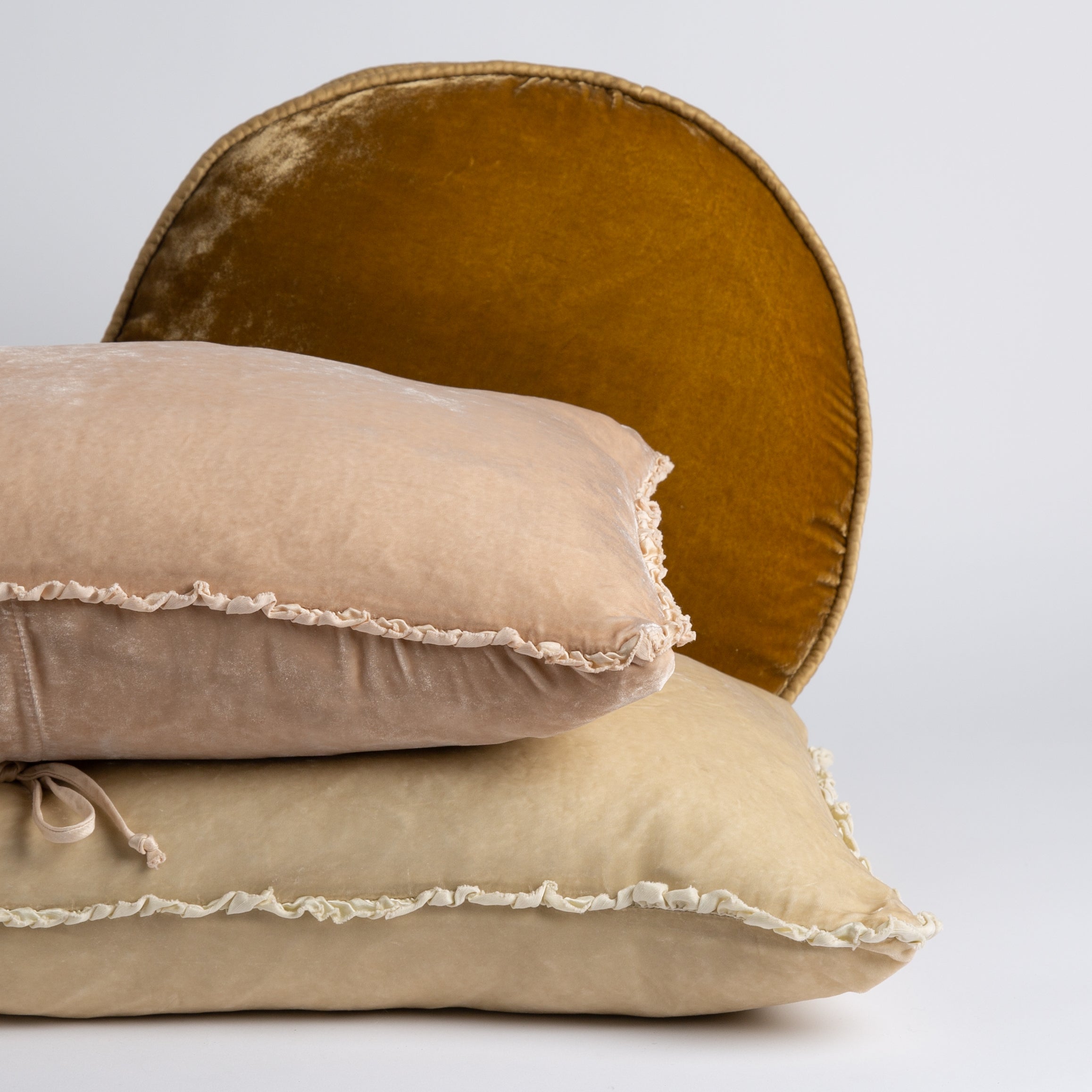: silk velvet pilows against a white background. The round pillow has a satin trim and the other two have a petite charmeuse ruffle.