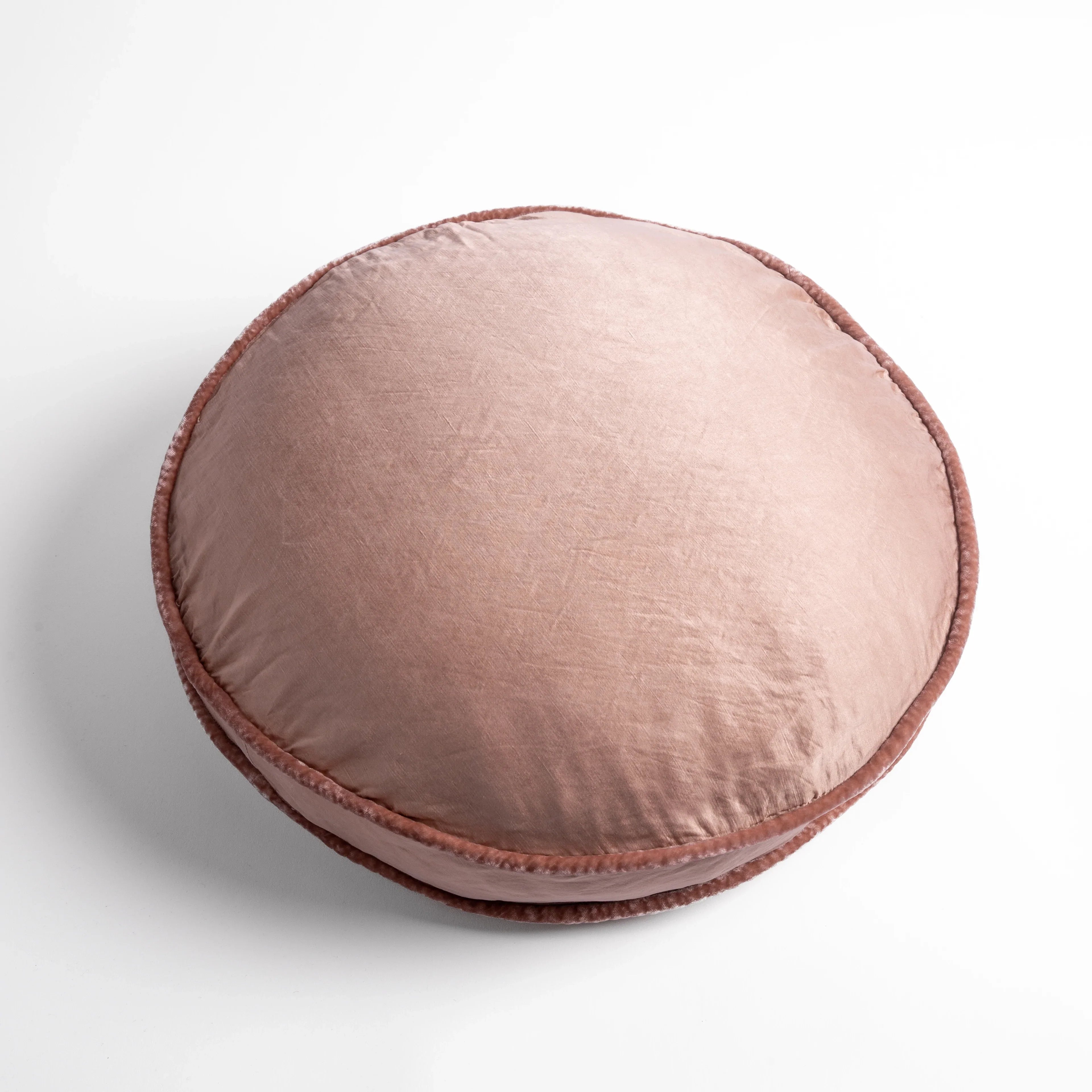 Rouge: 18" round charmeuse pillow with silk velvet trim at gusset shot from overhead on a white background