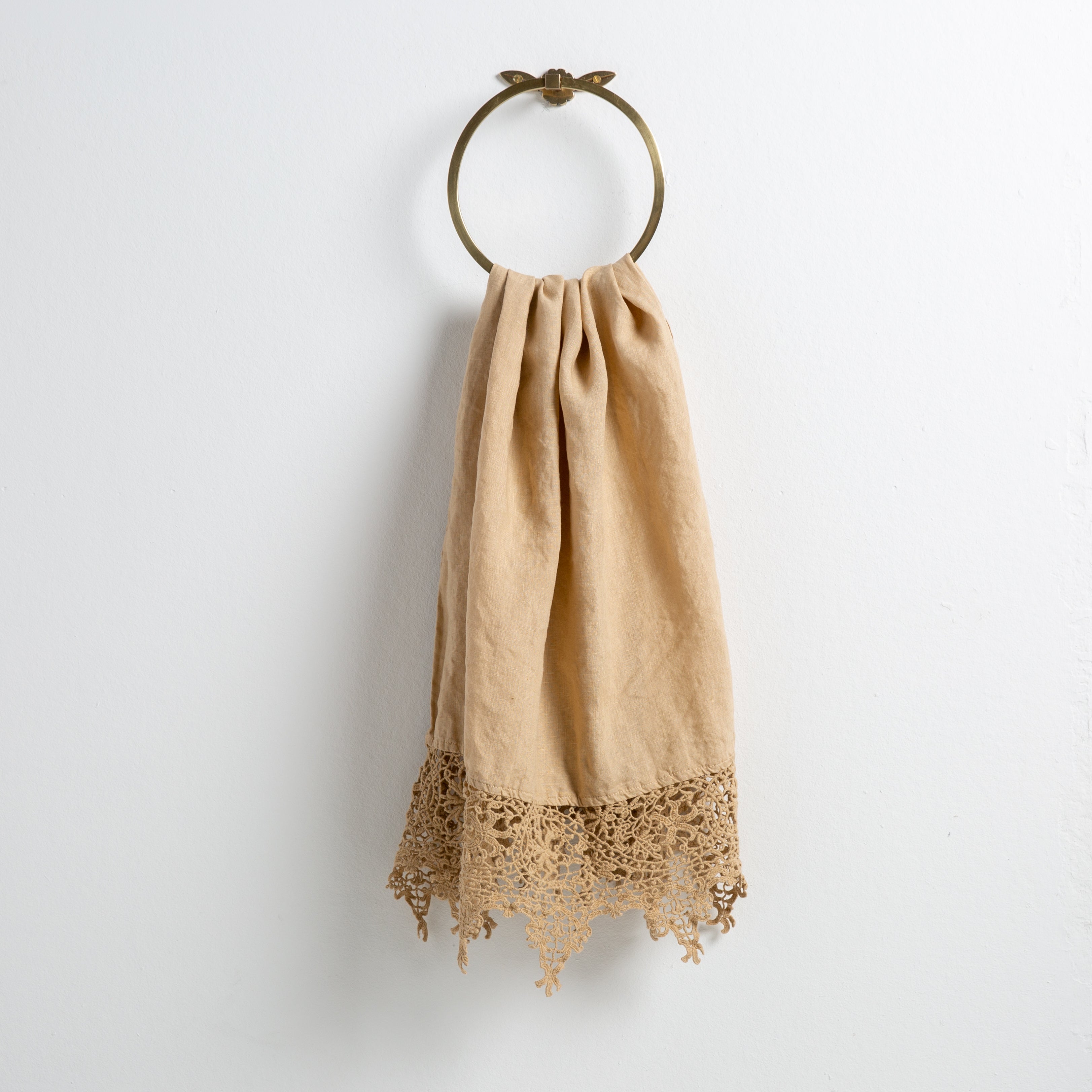 Honeycomb: Lace trimmed linen guest towel draped through a decorative towel ring against a plain white background.