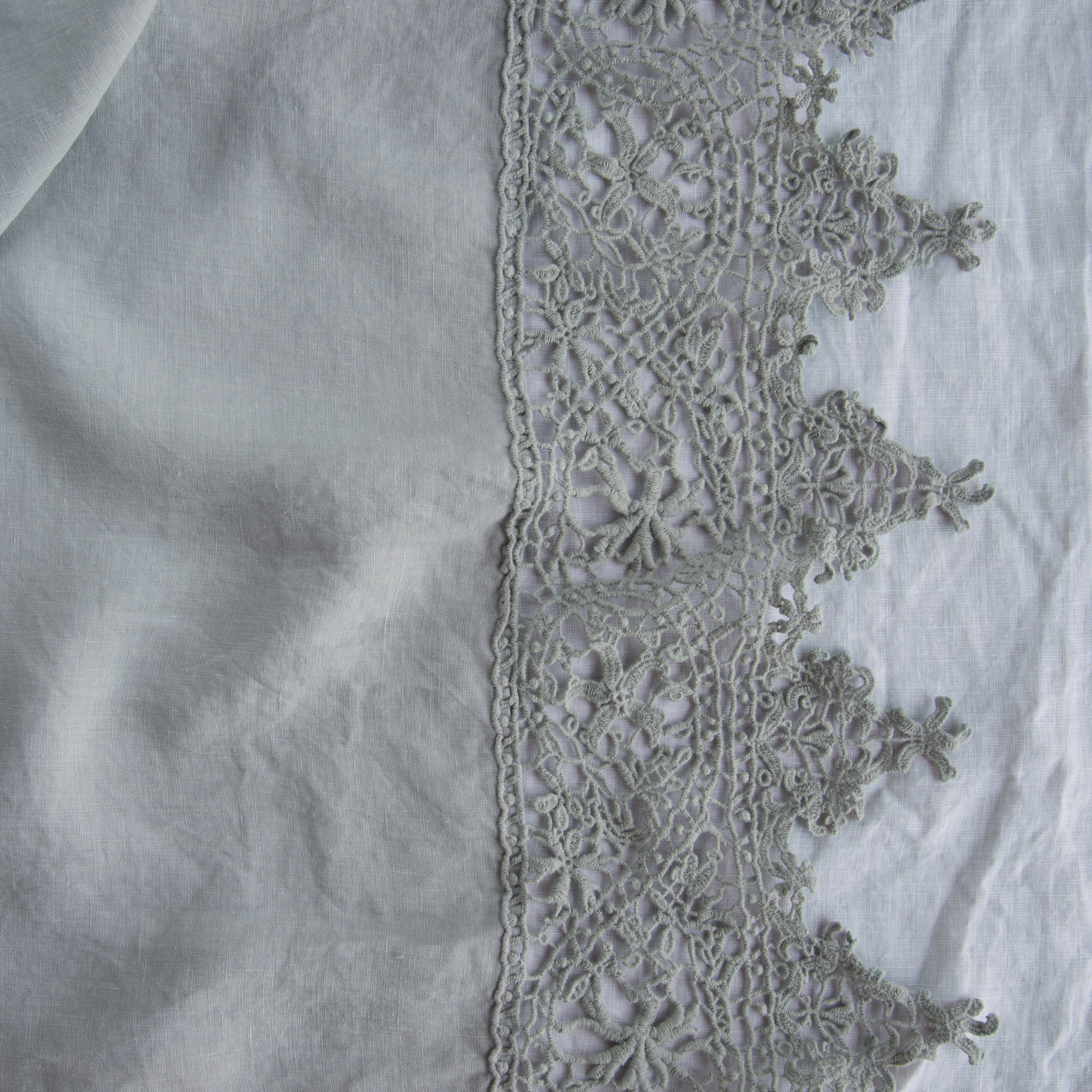 Mineral: A close up of Frida , an antique cotton lace trim on a linen body, shown in mineral, a soothing seafoam blue with subtle grey-green undertones.