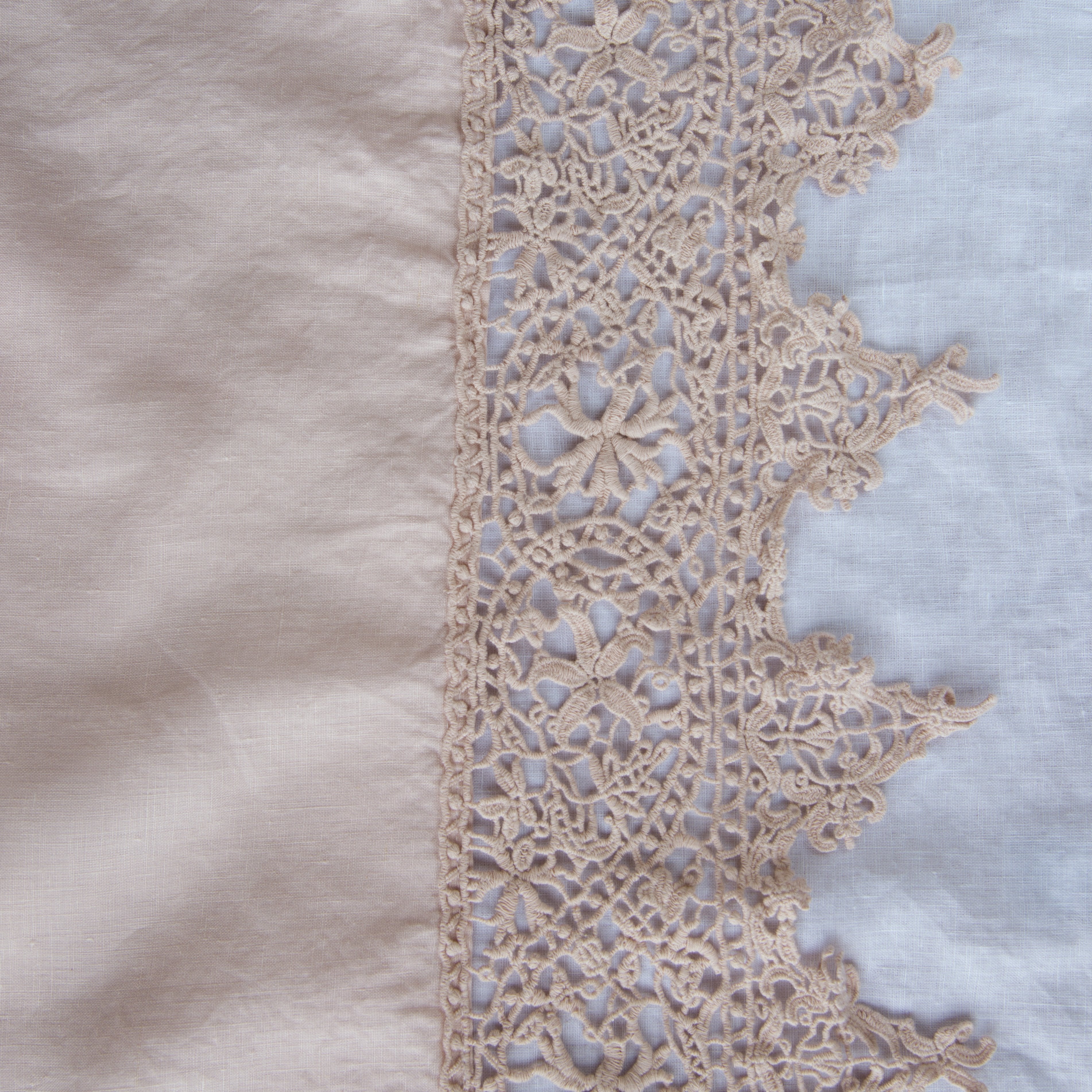 Pearl: A close up of Frida, an antique cotton lace trim on a linen body, shown in pearl, a nude-like, soft rose pink tone.