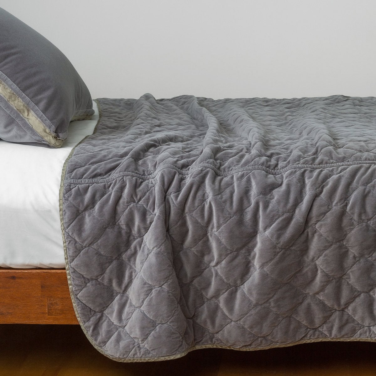 Moonlight: Quilted cotton velvet coverlet draped over a white fitted sheet - side view.