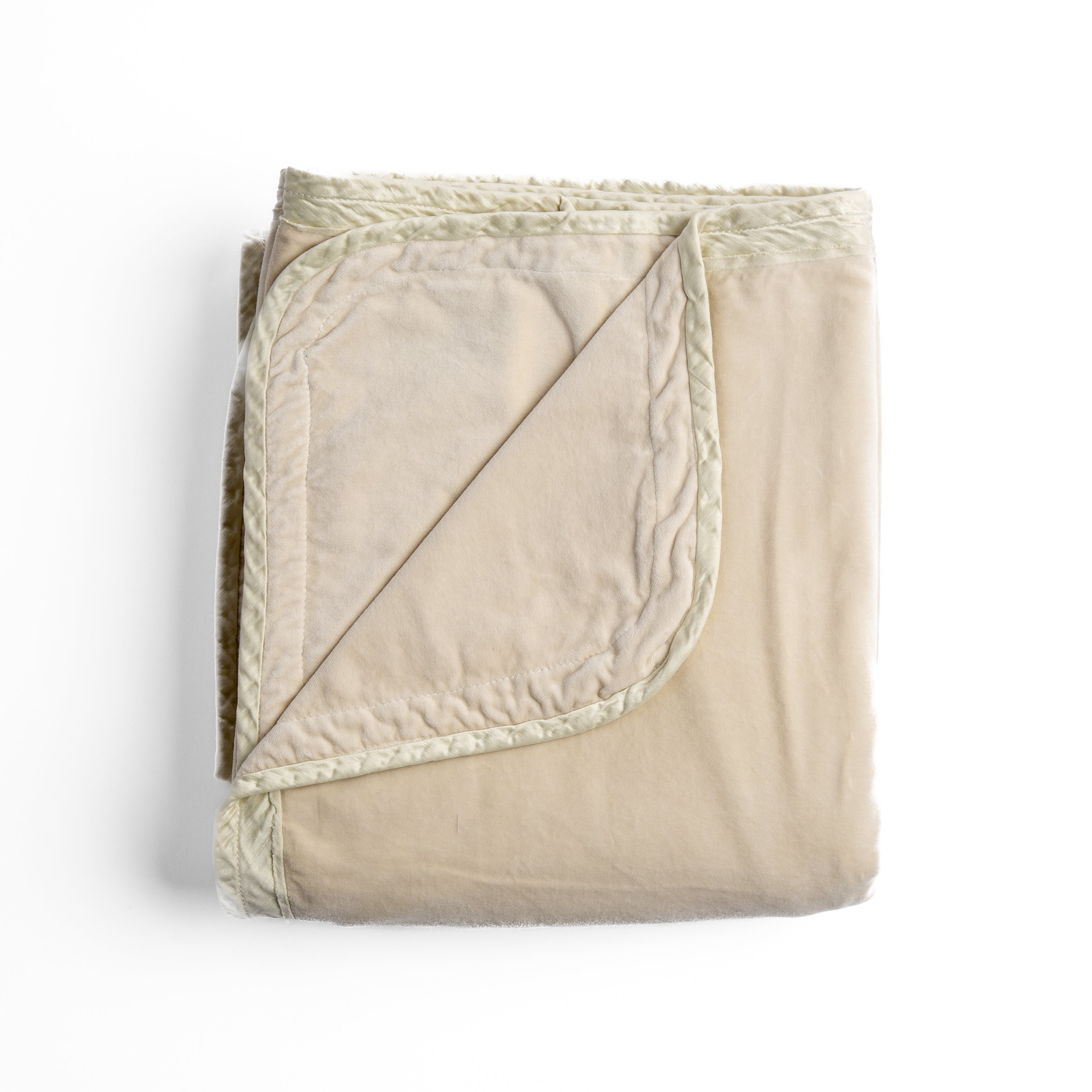 Parchmentr: overhead angle of the folded blanket with a corner pulled back to show the reverse and trim.