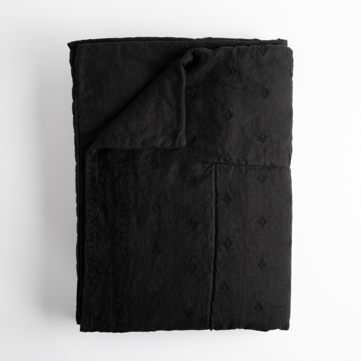 Corvino: folded bed end blanket with corner folded to show back; overhead angle on white background.