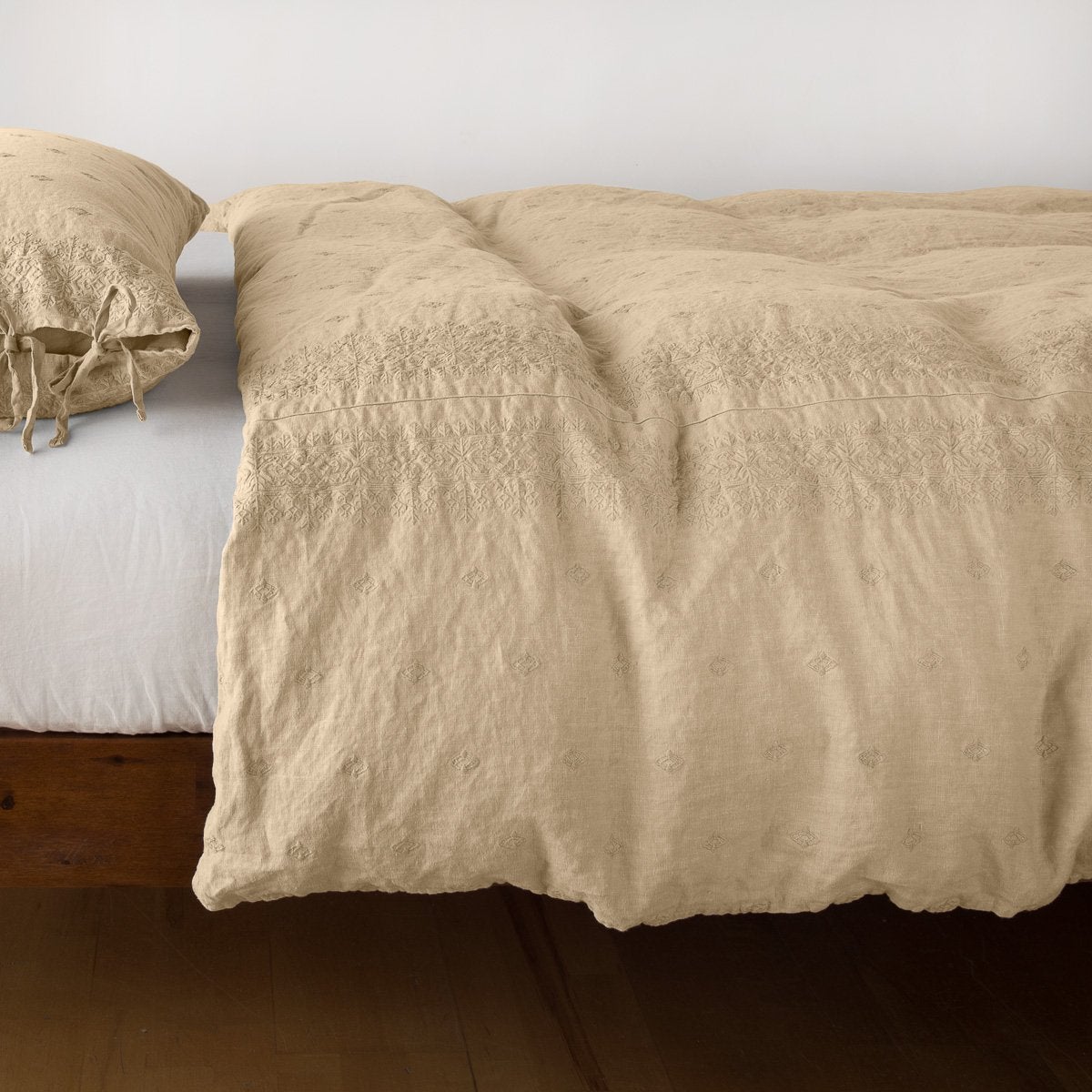 Honeycomb: lightly rumpled duvet cover on a monochromatic bed against a white background - side view.
