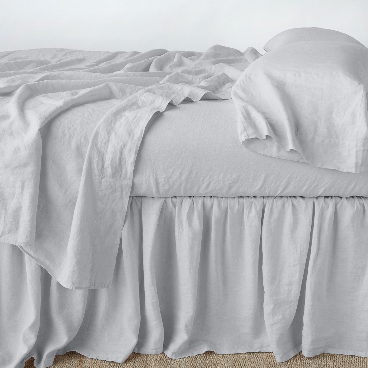 Sterling: bed skirt with matching rumpled sheets and sleeping pillows - side view.