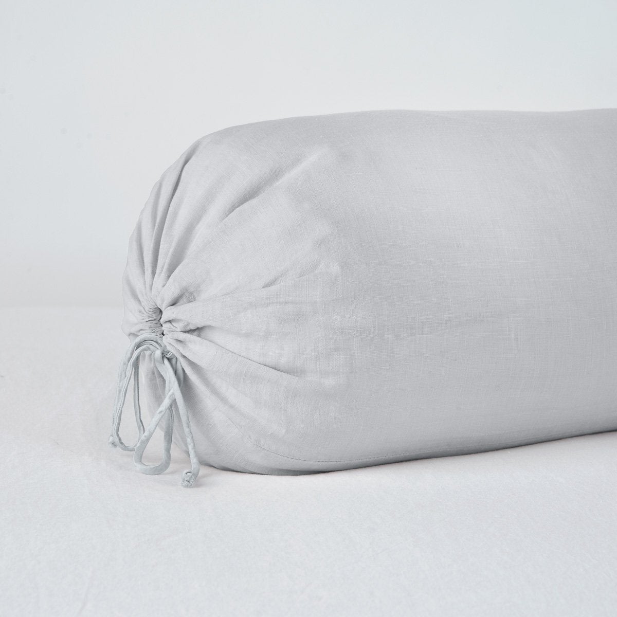 Sterling: Close-up bolster end detail, angled view to show gathered closure and satin ties.