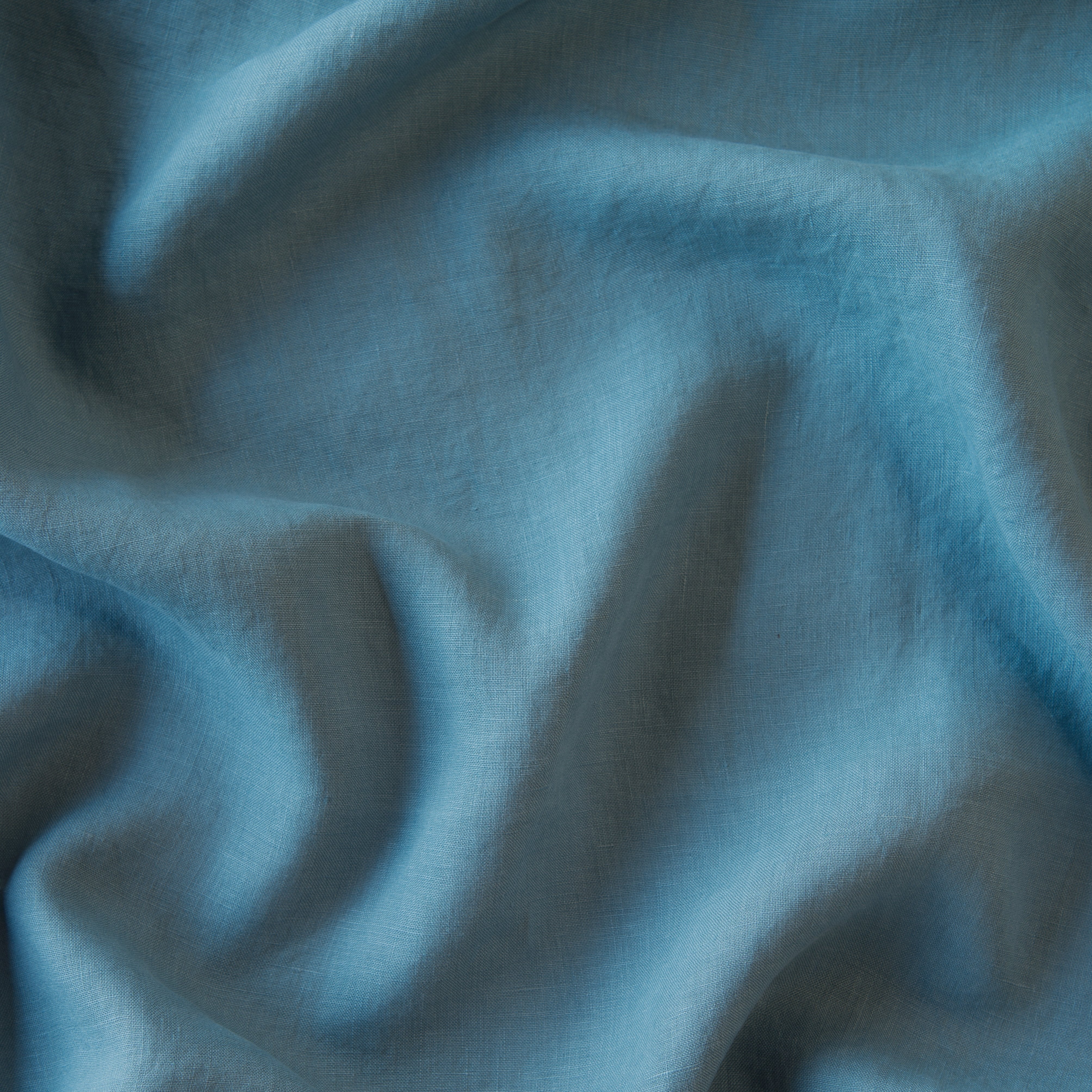 Cenote: A close up of linen in cenote, a vibrant, ocean-inspired blue-green.