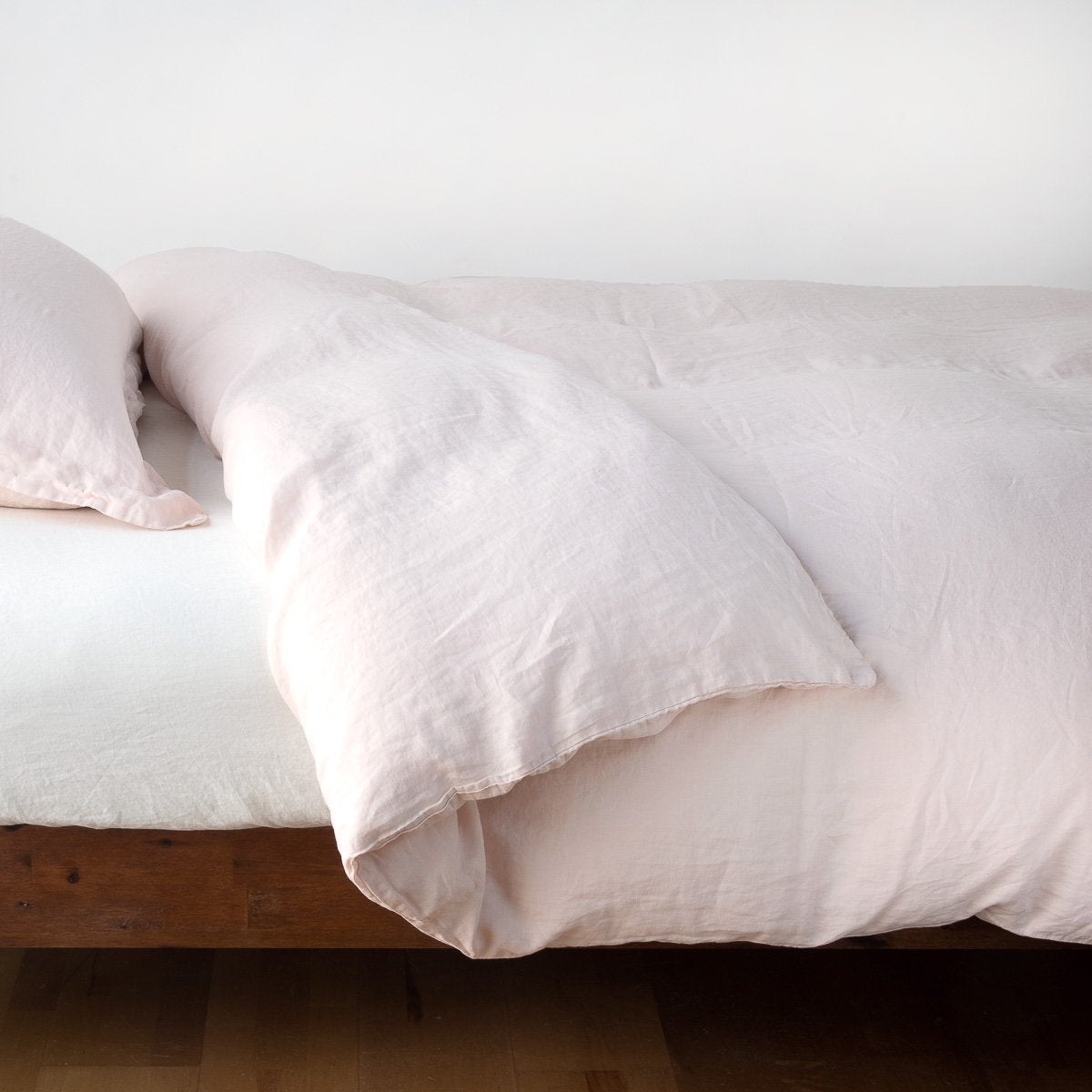 Pearl: duvet cover neatly folded back over white linen sheeting - side view.