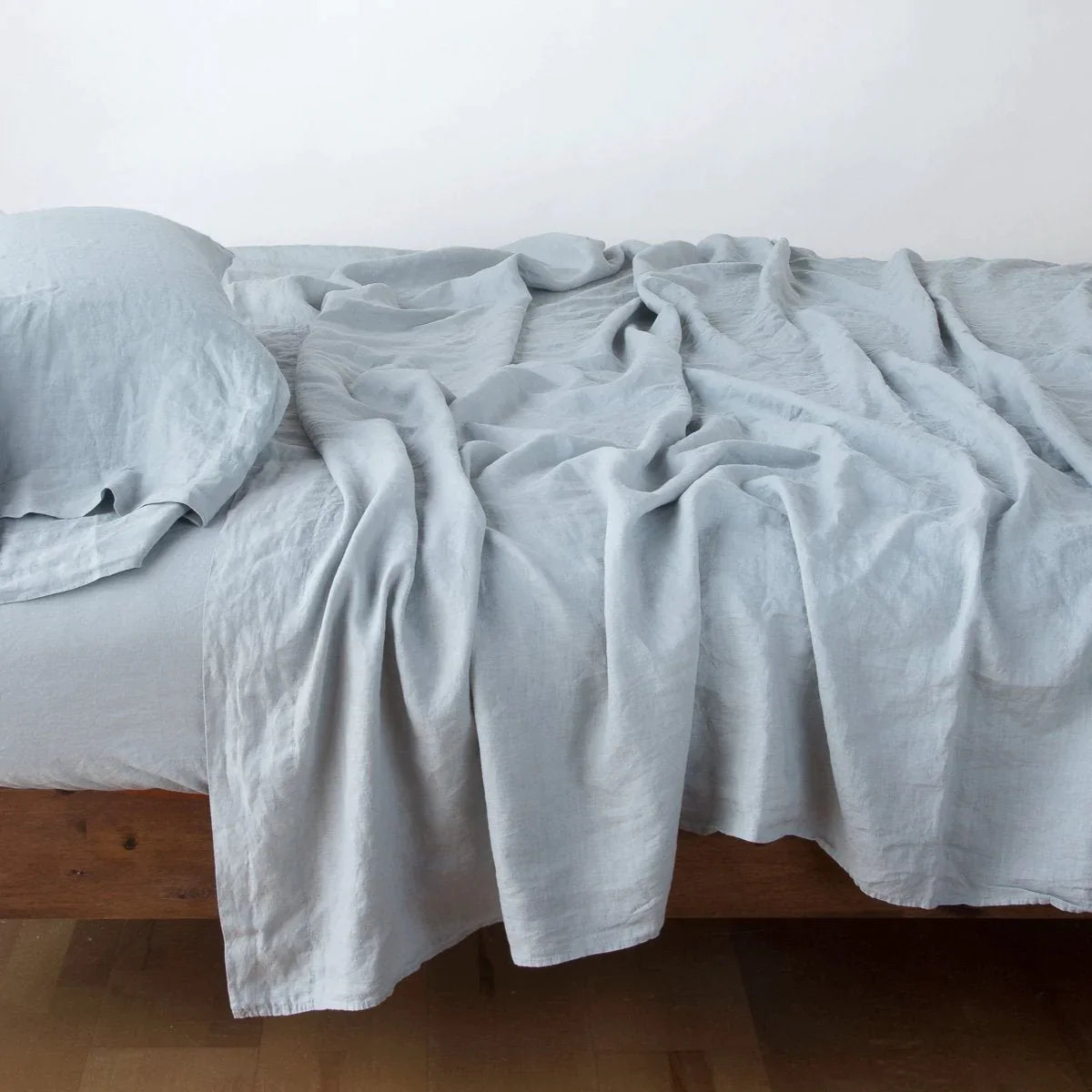 Mineral: fitted sheet with matching rumpled flat sheet and sleeping pillow - side view.