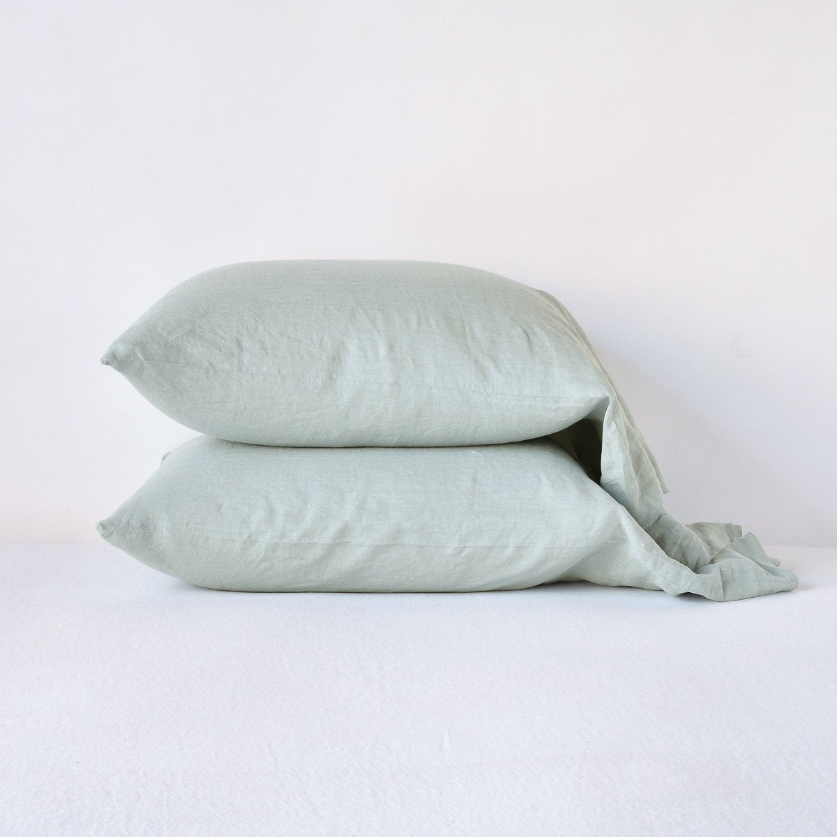 Eucalyptus: Two sleeping pillows neatly stacked against a white background - side view.