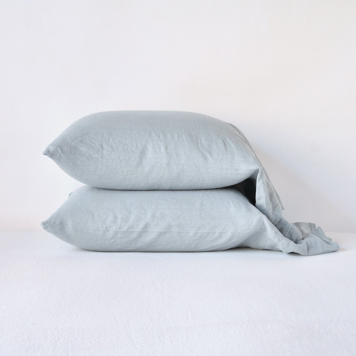 Mineral: Two sleeping pillows neatly stacked against a white background - side view.
