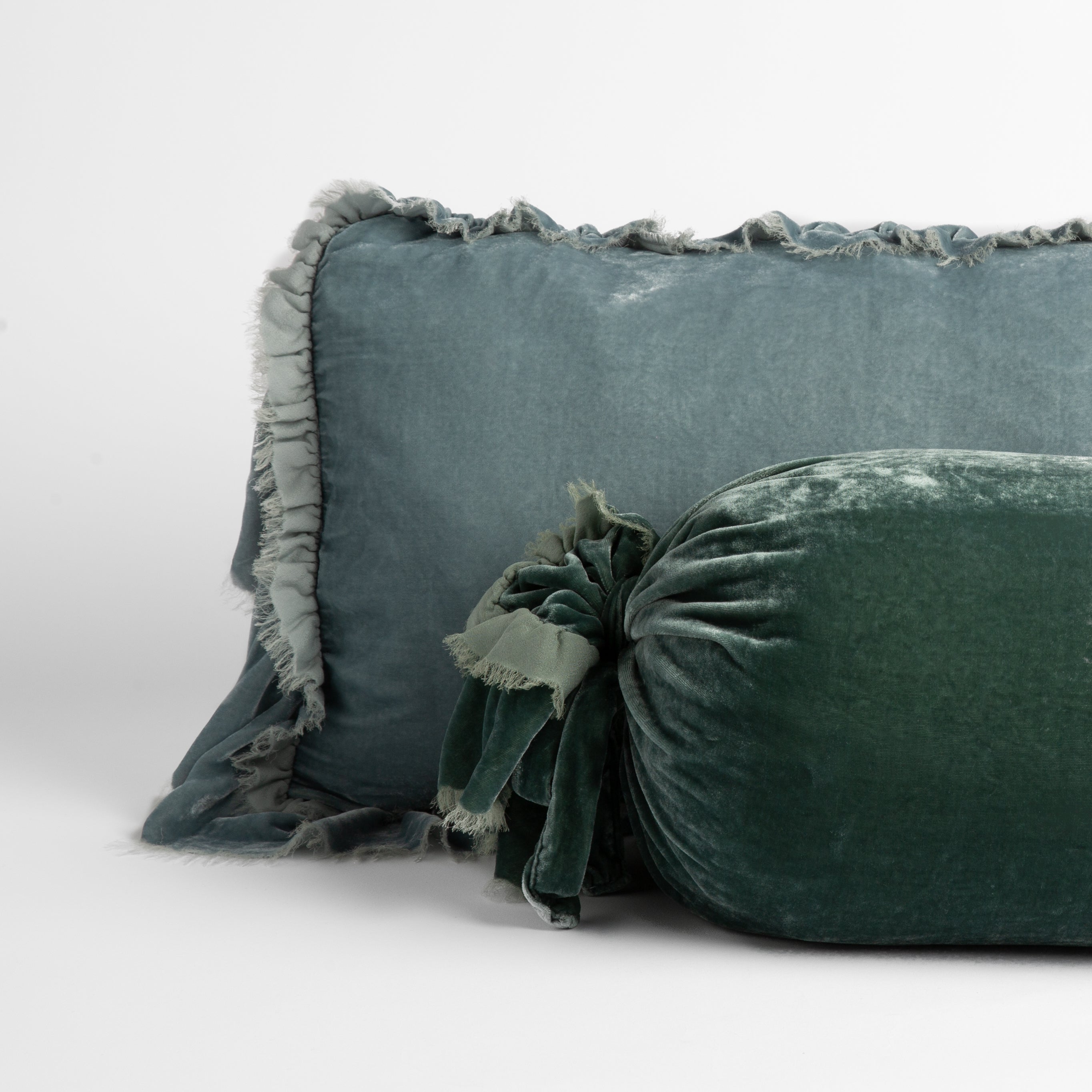 : silk velvet throw pillows with raw edge ruffle details; cool tones straight on against a white background.