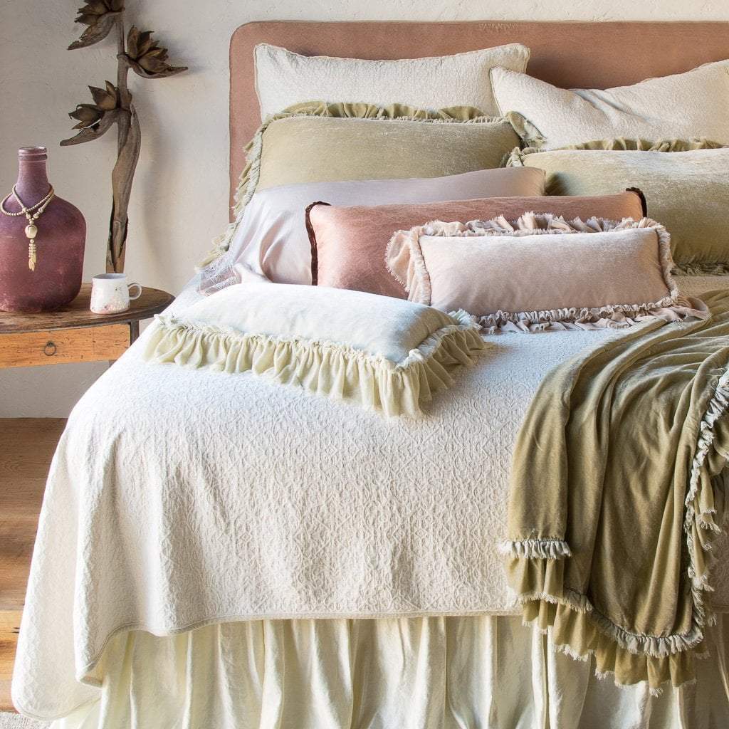 : Loulah Accent pillows with matching shams and throw blanket, layered with silk charmeuse and cotton chenille jacquard, in cream, pink, and gold tones - end of bed view.