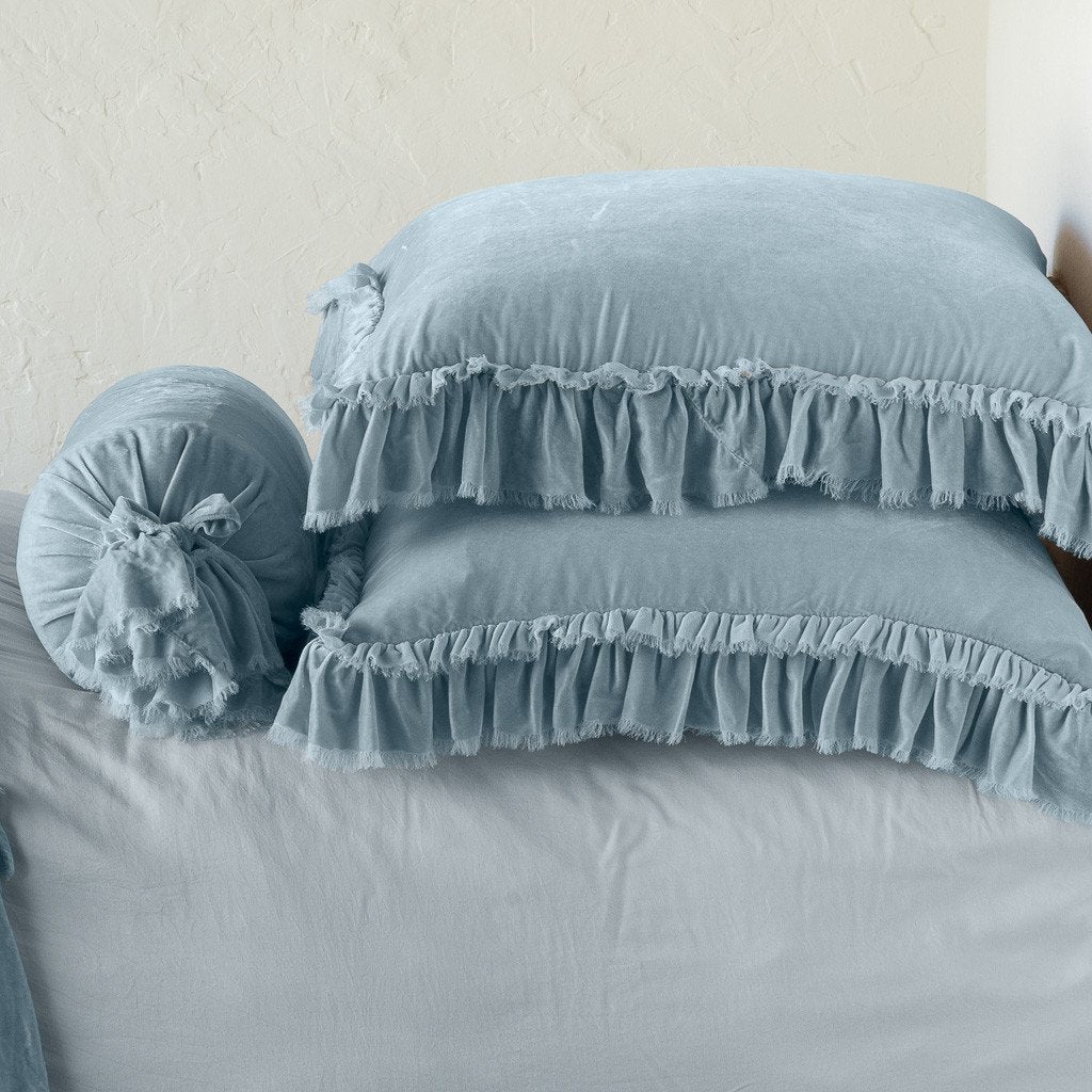 Cloud: Two shams stacked flat next to matching bolster. Close-up side view highlights the ruffle trim.