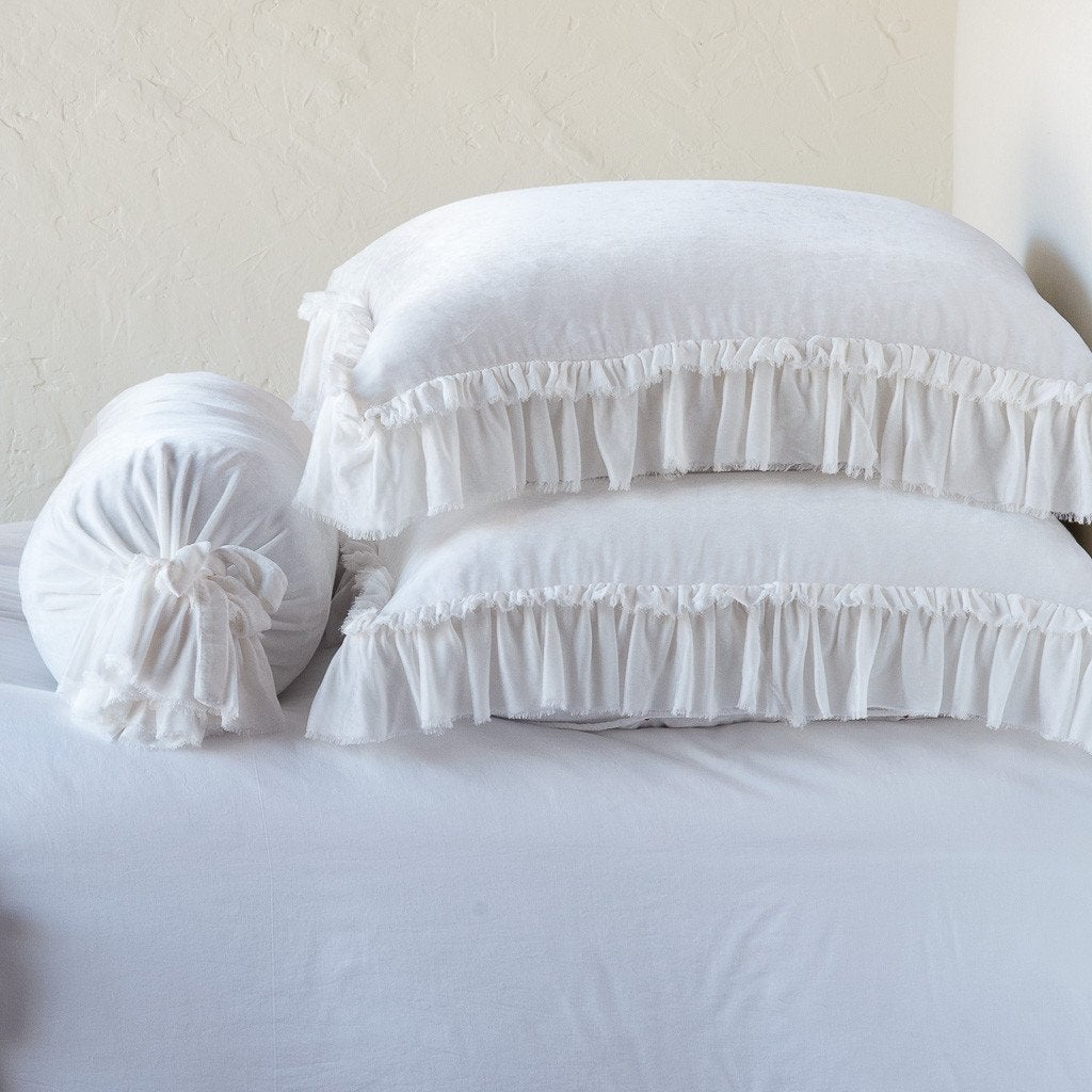 White: Two shams stacked flat next to matching bolster. Close-up side view highlights the ruffle trim.