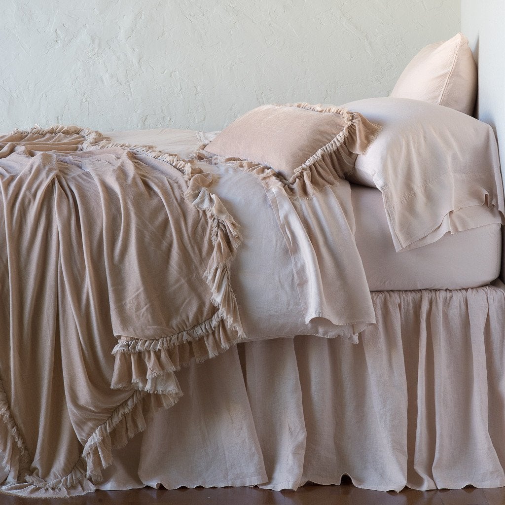 Pearl: throw blanket draped over a monochromatic bed, shown with matching throw pillow - side view.