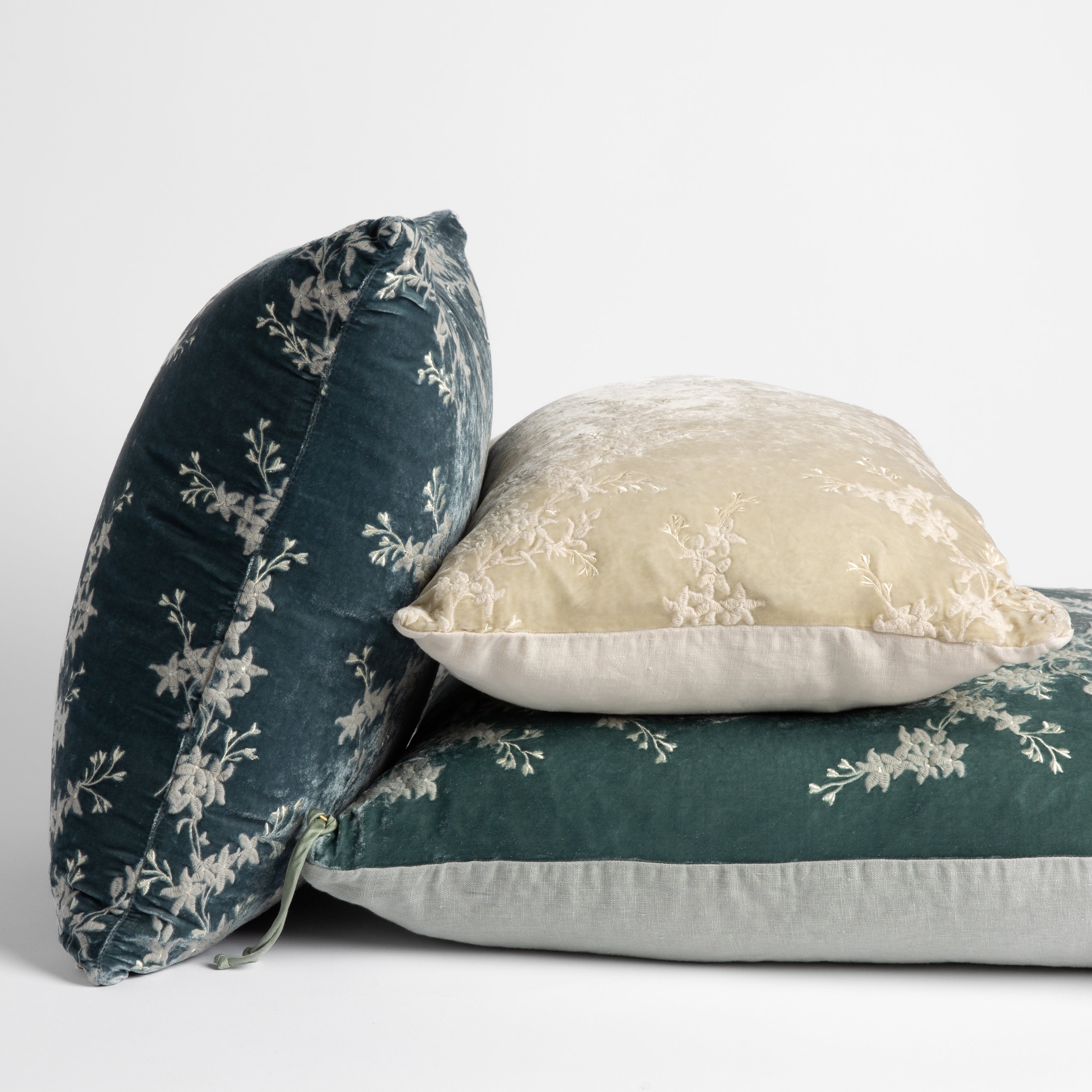 : embroidered silk velvet throw pillows stacked to show both sides of all pillow styles — straight on against a white background.