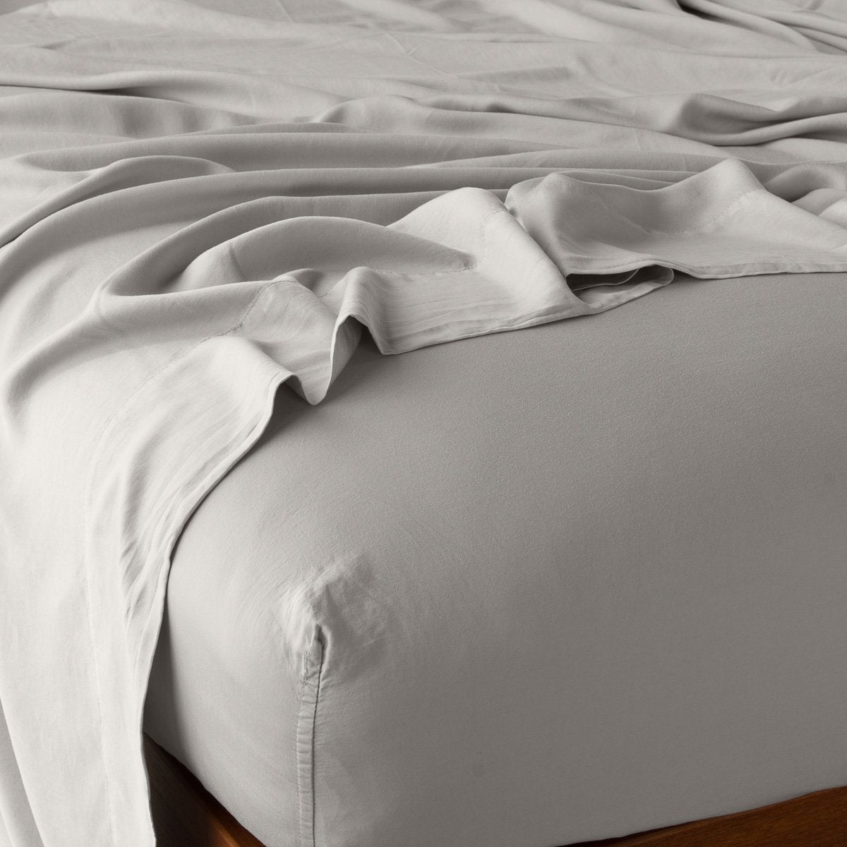 Fog: fitted sheet with matching rumpled flat sheet - top corner view.