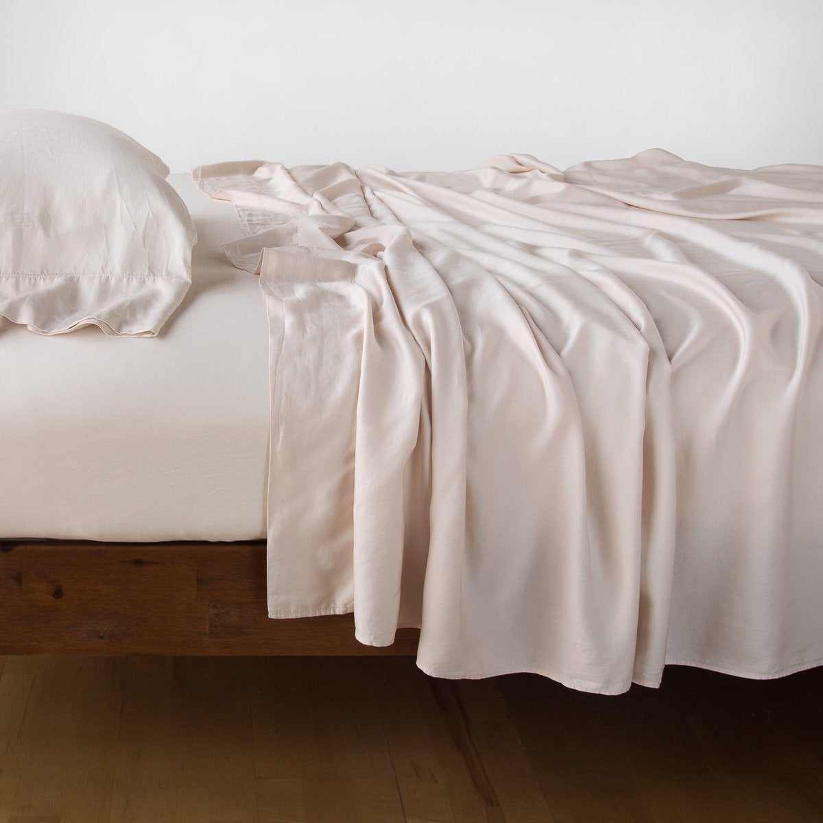 Pearl: fitted sheet with matching rumpled flat sheet and sleeping pillow - side view.