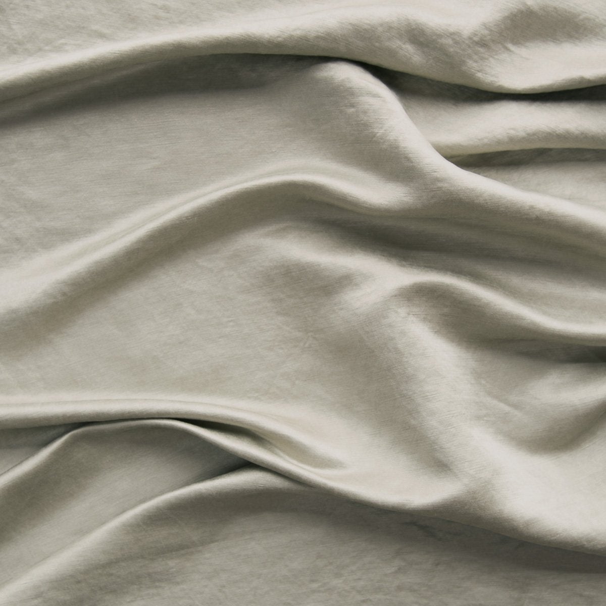Fog: Close-up of silk charmeuse in fog, a neutral-warm, soft mid-tone grey.