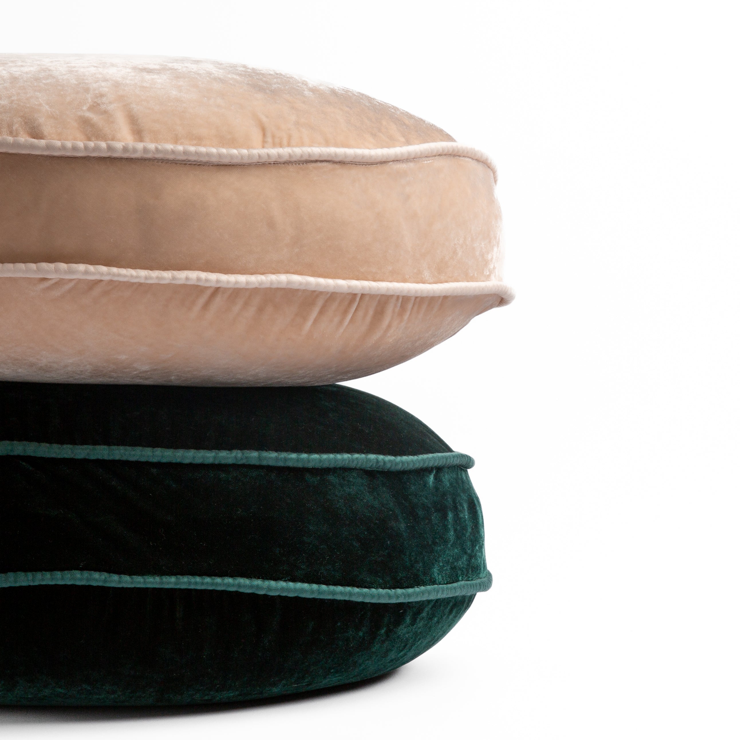 : two silk velvet round pillows stacked in pearl and jade against a white background.